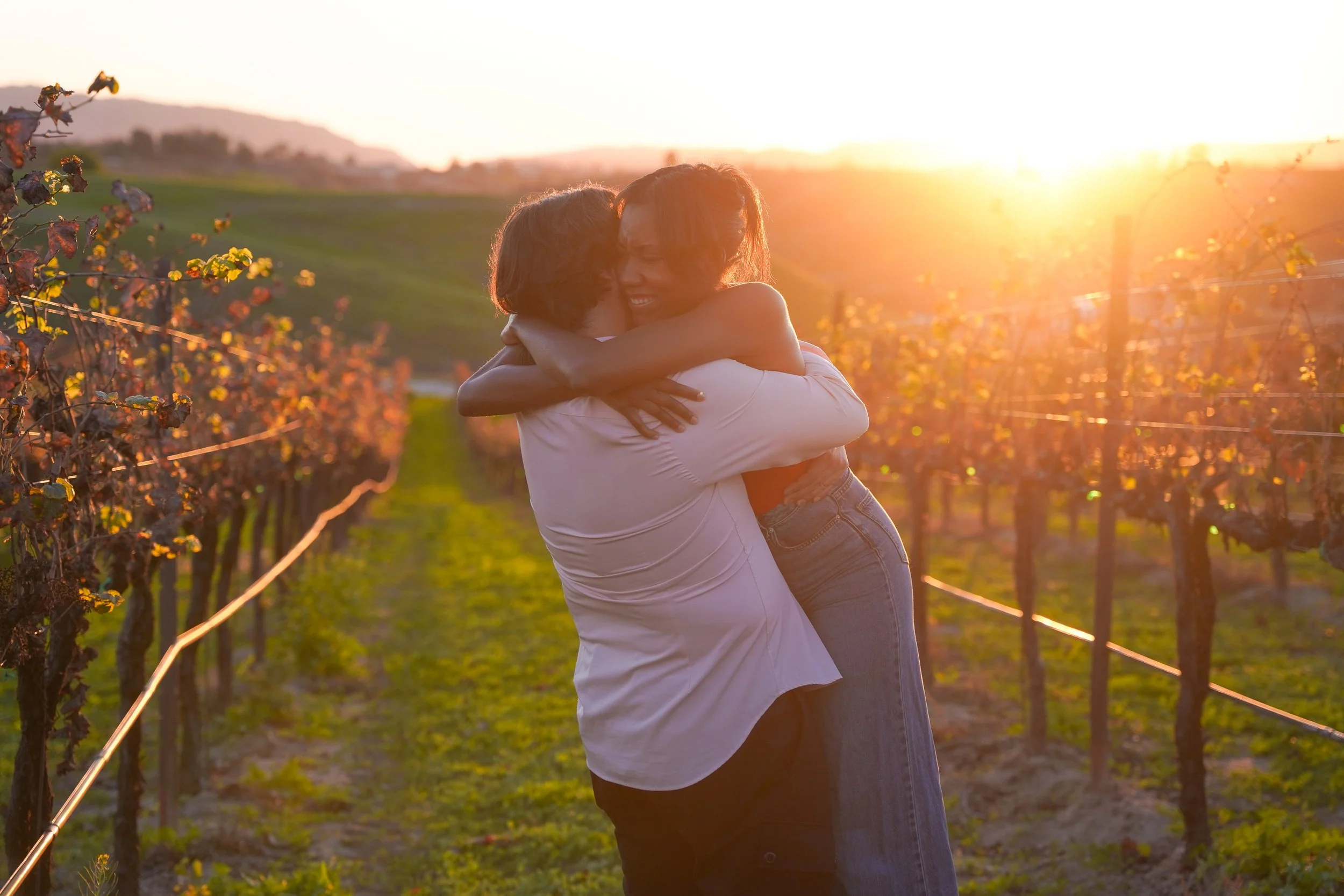 Golden hour surprise proposal at Carter Estate Winery, capturing the exact moment he drops to one knee among rolling vineyards as the sun sets, photographed by an experienced Temecula surprise proposal photographer.