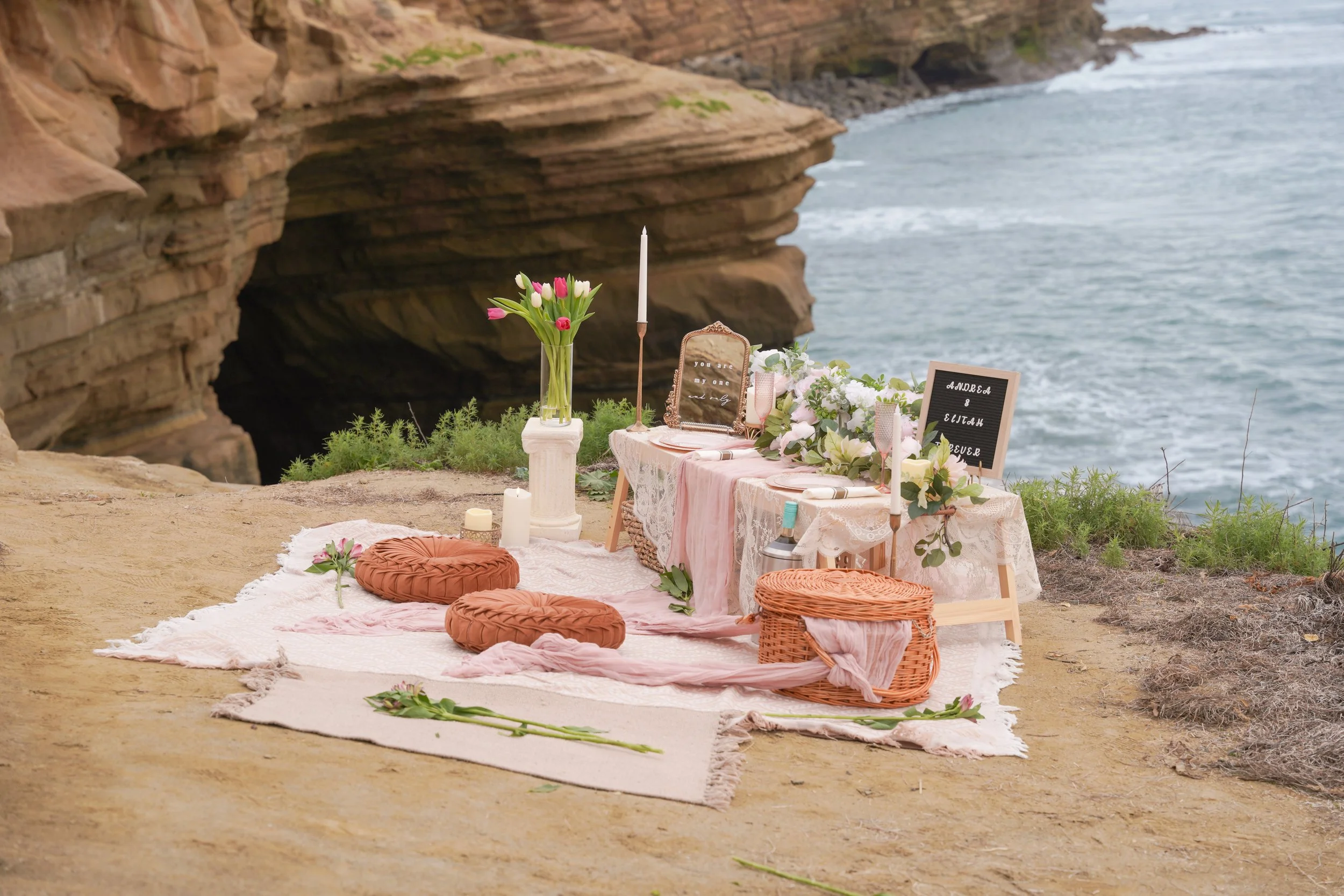 Cliffside boho proposal picnic at Sunset Cliffs San Diego with styled rug, low table décor, and ocean backdrop at golden hour