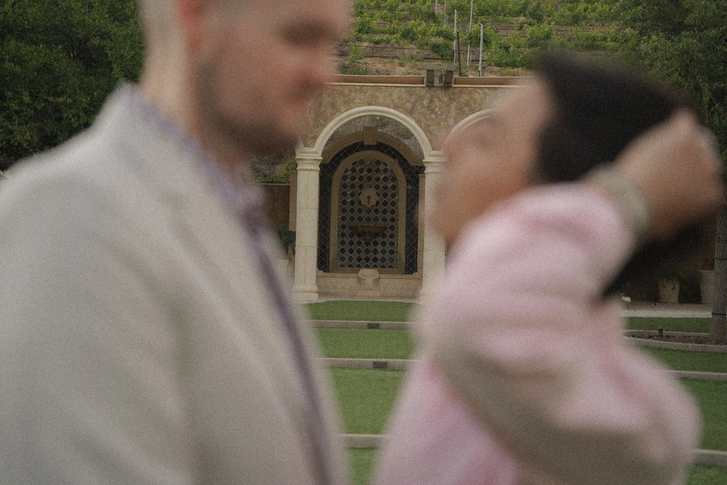 Couple sharing eye contact after proposal at Vienza courtyard inside Europa Village Wineries & Resort, Temecula winery engagement photo with soft cinematic editing, captured by a surprise proposal photographer