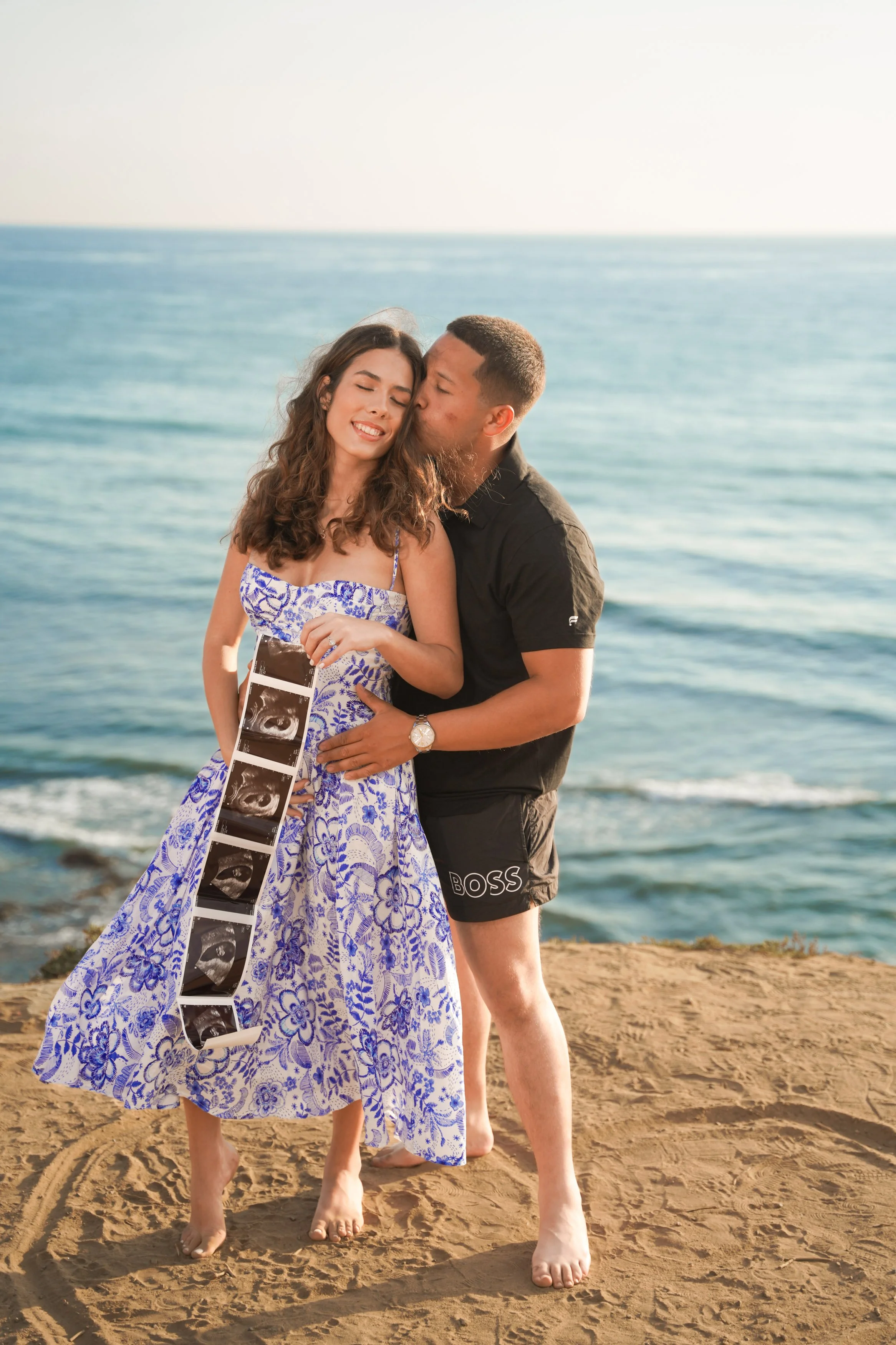 Golden hour baby announcement photography at Sunset Cliffs San Diego with glowing skies, breathtaking cliffs, and romantic ocean views, book your unforgettable reveal photography session today.