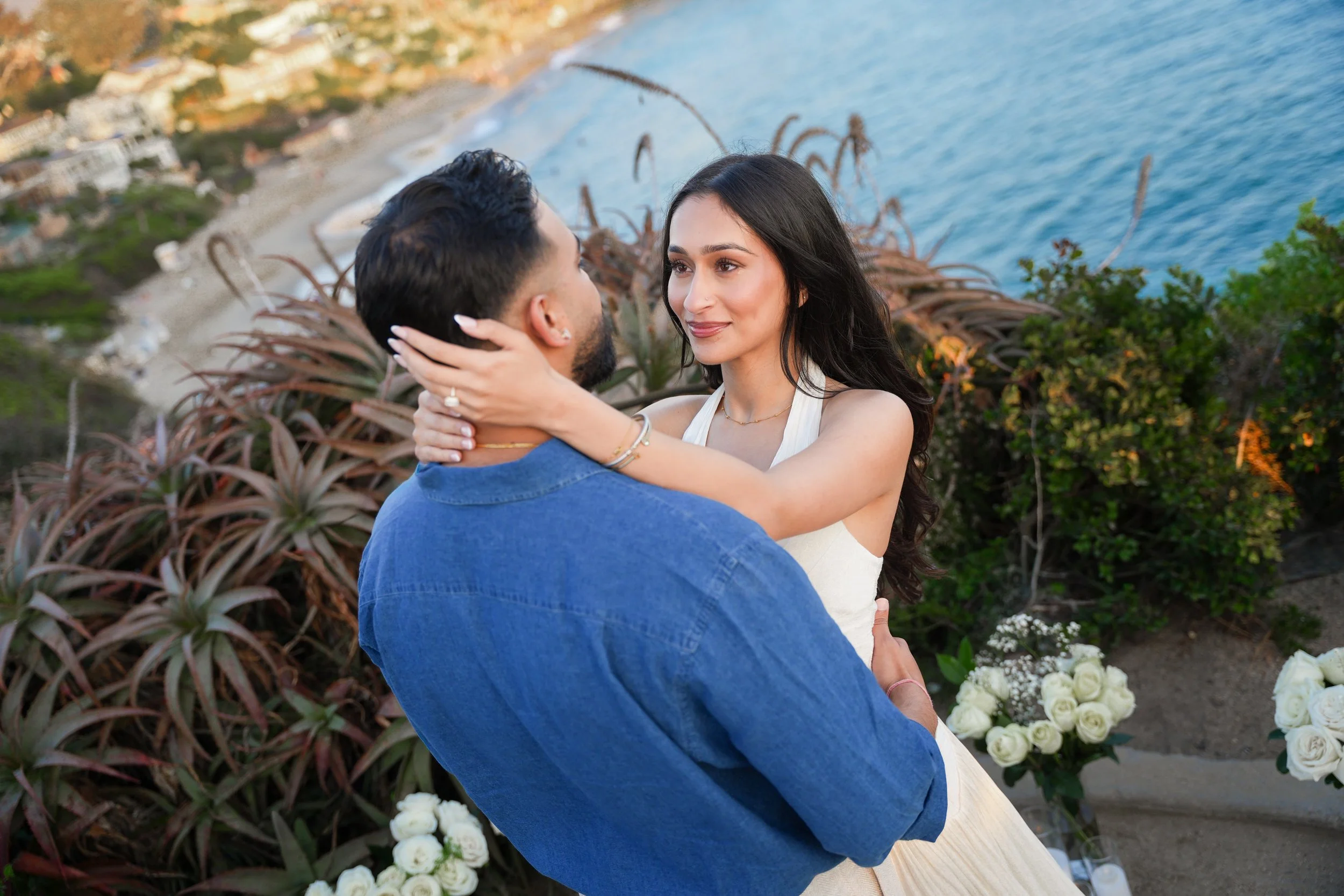 Couple celebrating their engagement beside the Grand Floral Yes arrangement.