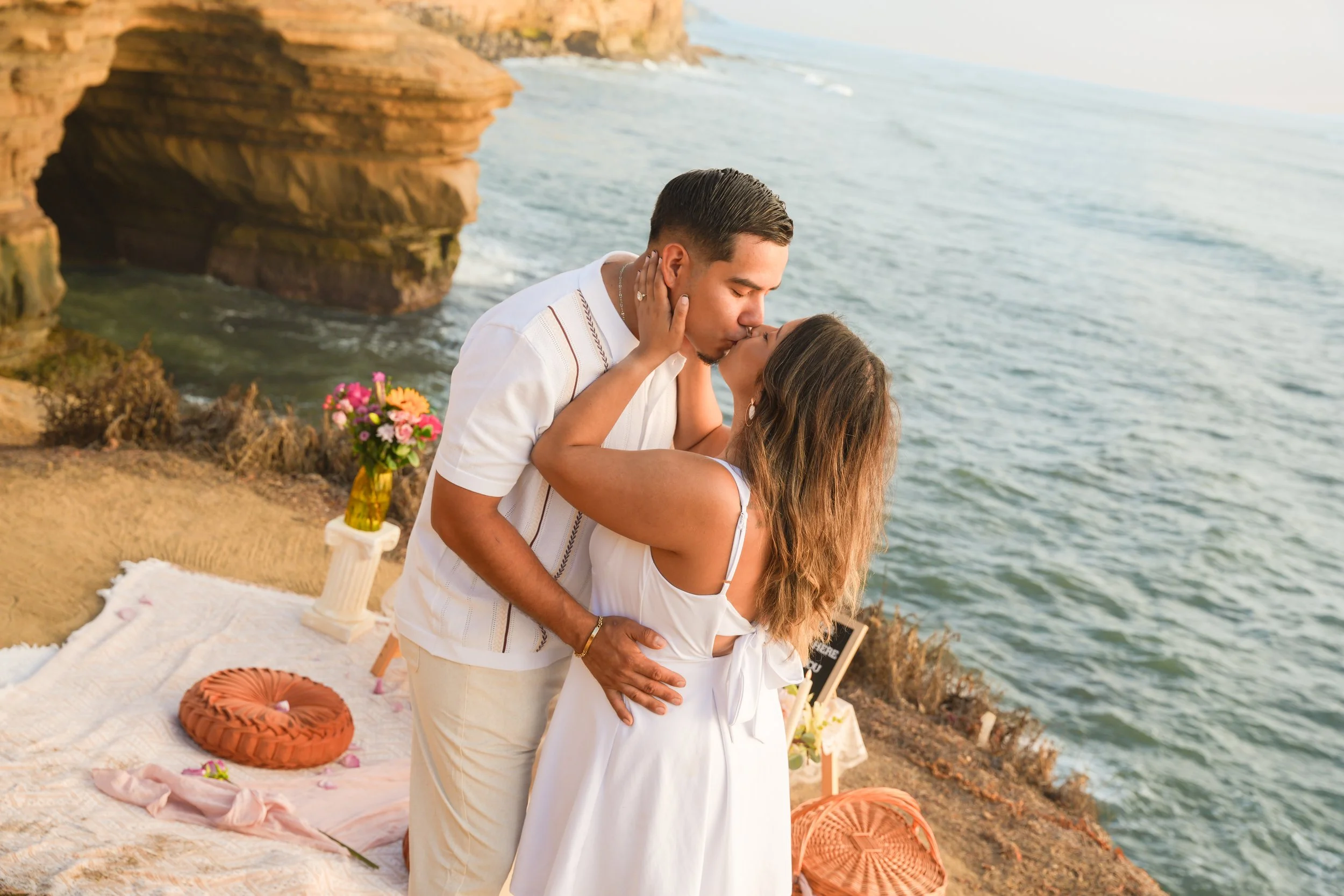 Alex kissing his fiancée Sayra after their surprise proposal at Sunset Cliffs in San Diego, California.