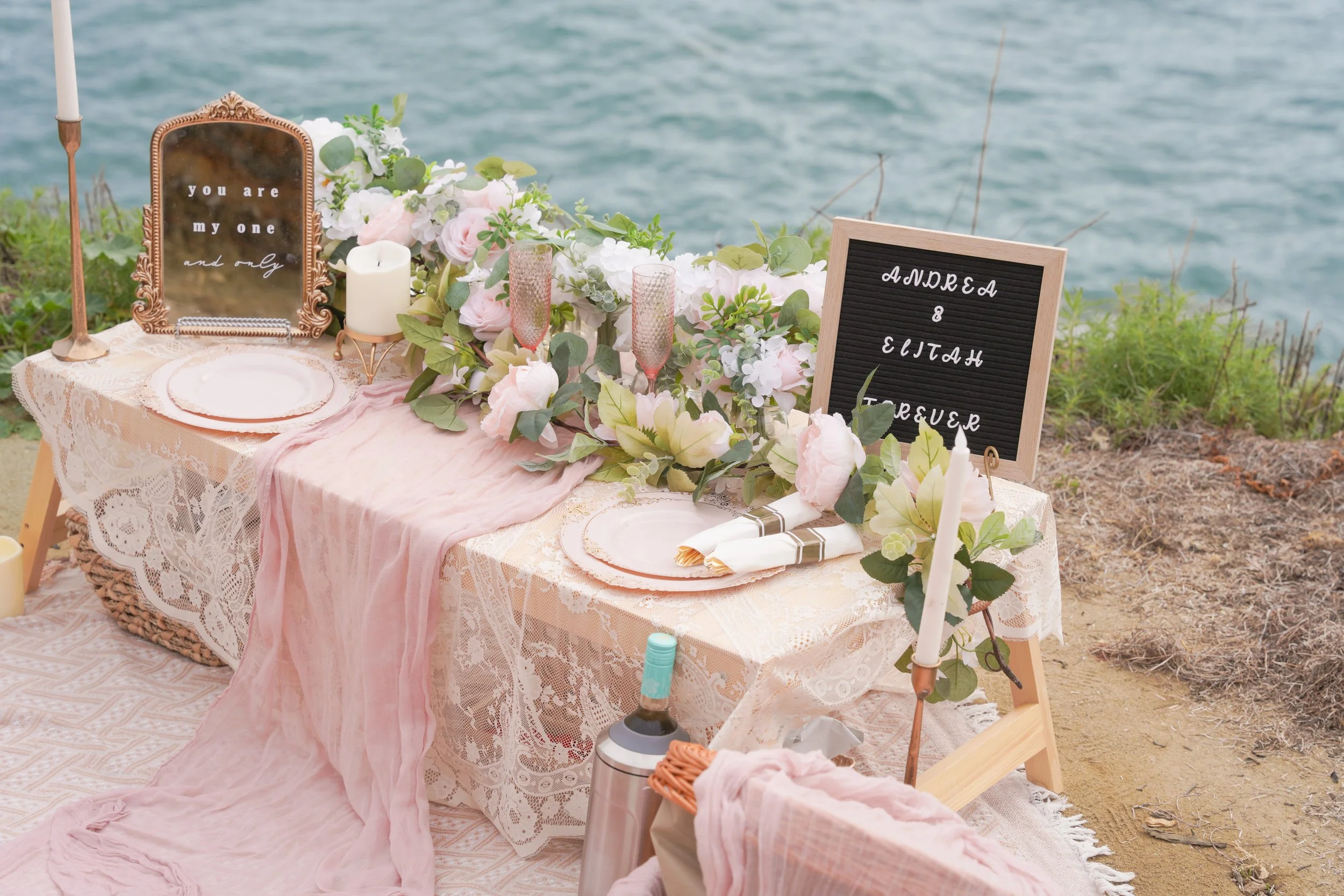 Romantic cliffside proposal picnic at Sunset Cliffs with boho décor and professional photography capturing sunset light
