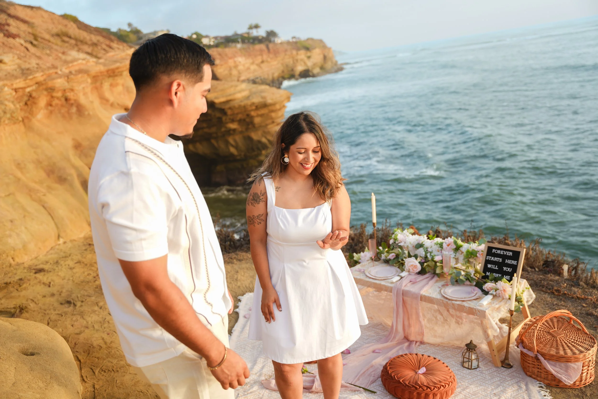 Sayra admiring her engagement ring after Alex’s surprise proposal at Sunset Cliffs in San Diego, California.