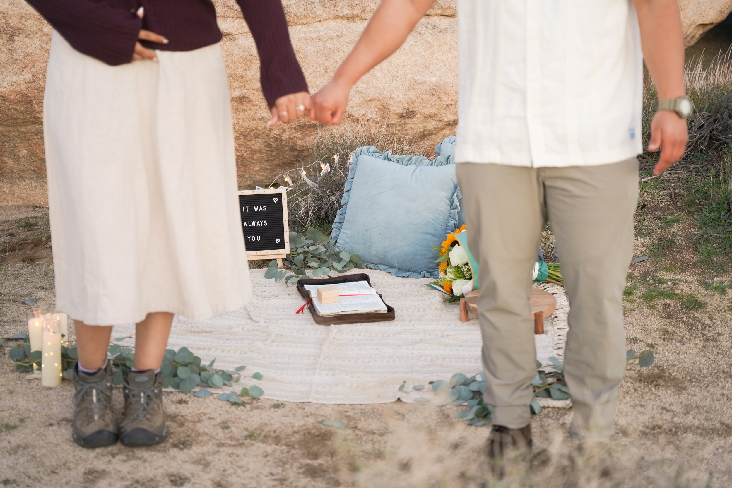Newly engaged couple celebrating after a surprise proposal at Hall of Horrors in Joshua Tree National Park, captured in warm desert light.