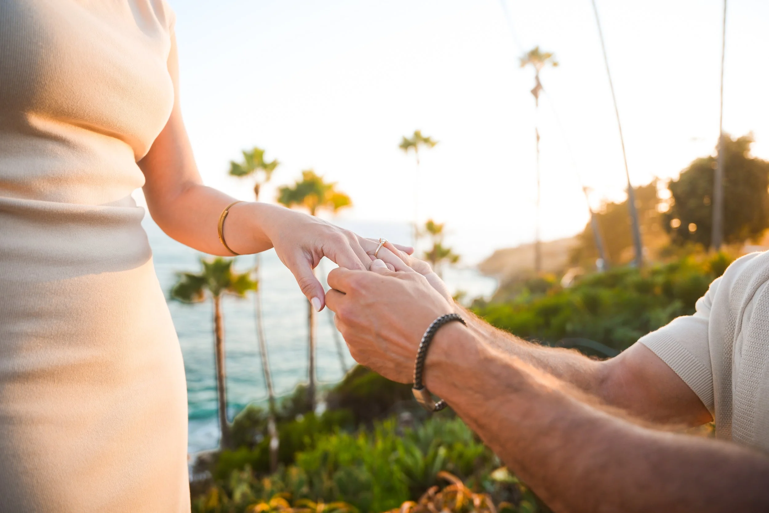 Derek proposing to Bella at Heisler Park in Laguna Beach, California, during their sunset surprise proposal.