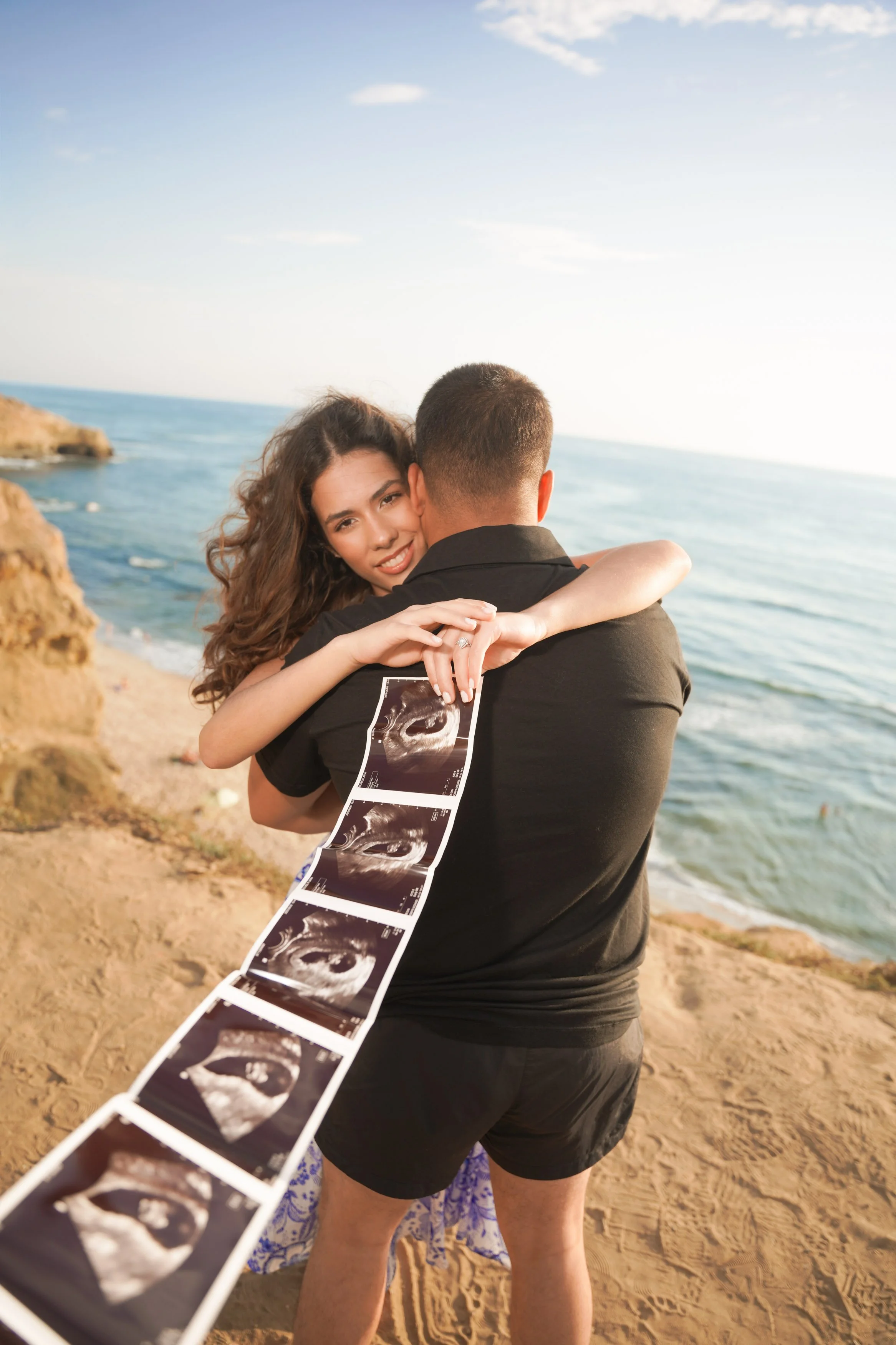 Maternity and baby announcement photography in San Diego during golden hour at Sunset Cliffs beach with cinematic cliffs, glowing skies, and ocean views, book your timeless reveal session today.