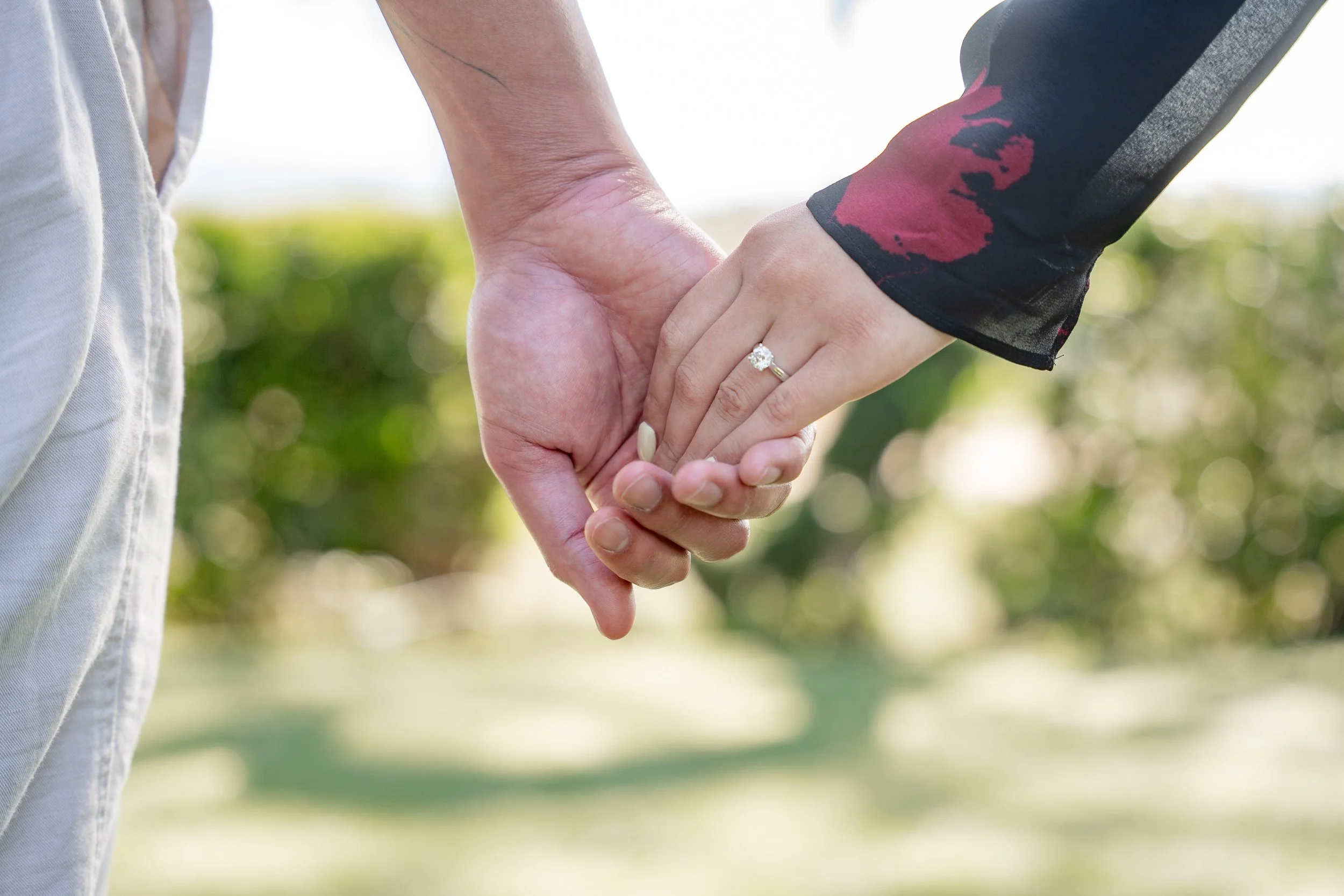 Couple holding hands during an engagement photoshoot at a Temecula winery with soft golden hour lighting