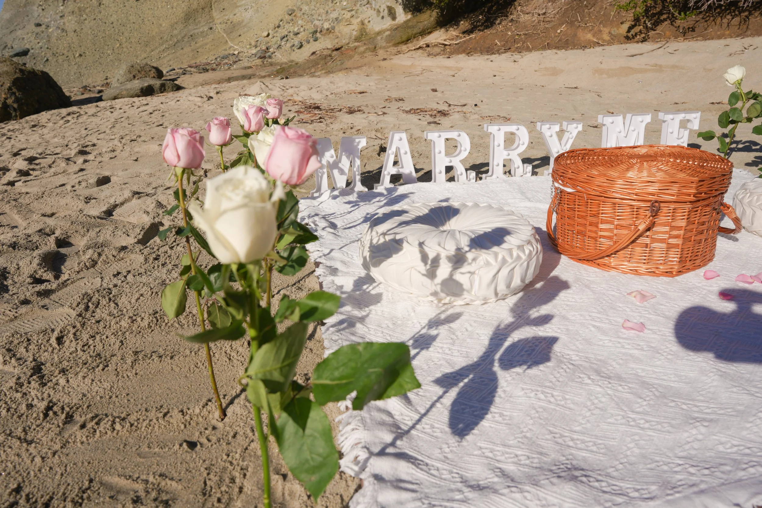 An elegant beach surprise proposal with Marry Me décor, blending romantic styling with natural ocean scenery for a timeless engagement moment.