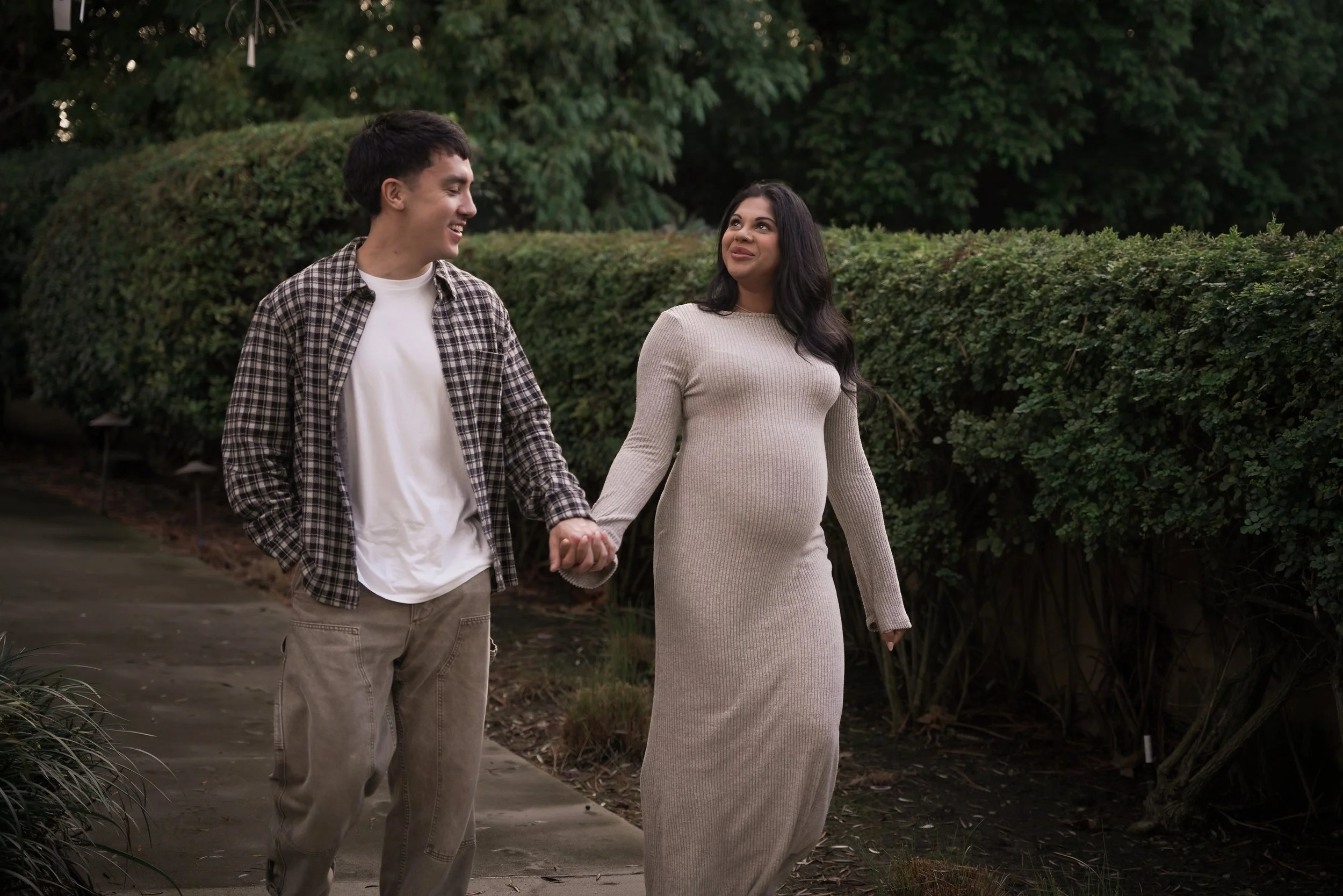 Couple walking hand-in-hand through the gardens at Estancia La Jolla after their Wishing Tree proposal, captured with soft golden light and natural movement.