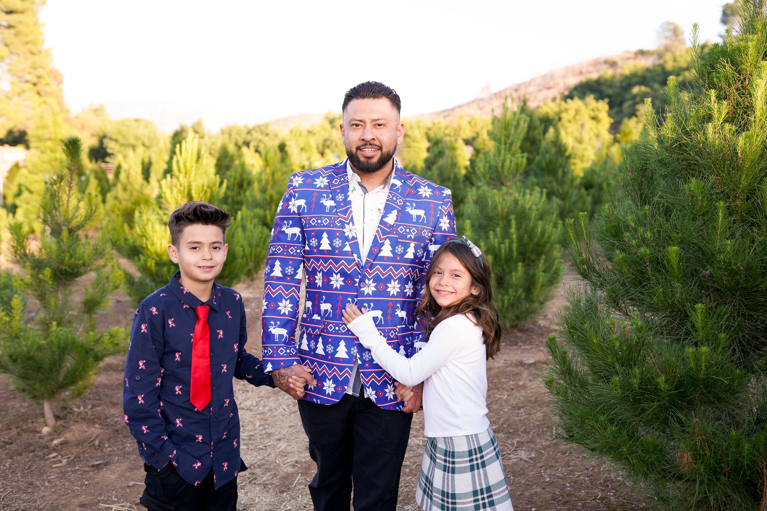 A cozy holiday session capturing a family's joy as they picked out their Christmas tree and placed the star on top. A beautiful moment of togetherness and new traditions—perfect for holiday family photography filled with warmth and cheer.