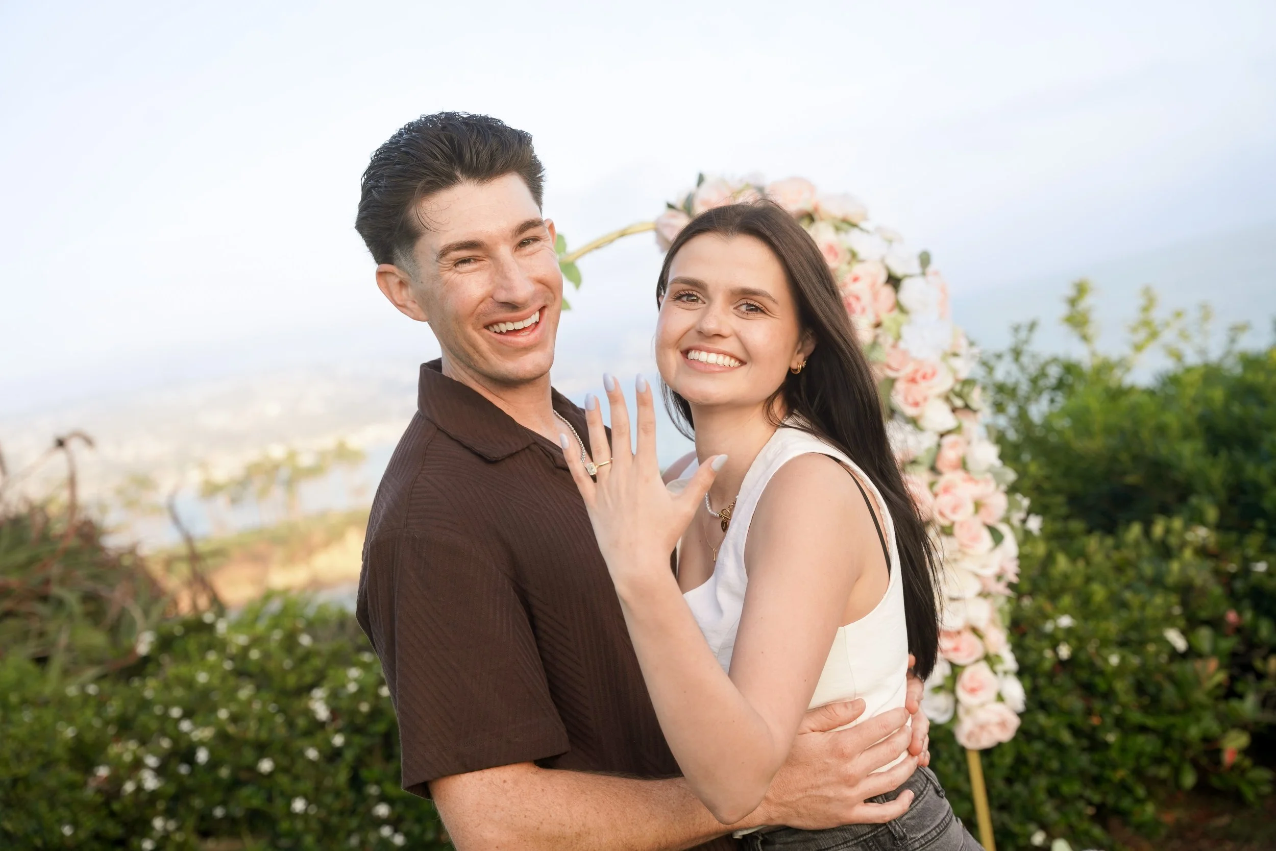 A newly engaged couple celebrates after a romantic Laguna Beach proposal planned through our Last Minute Yes package and Signature Yes add-on.