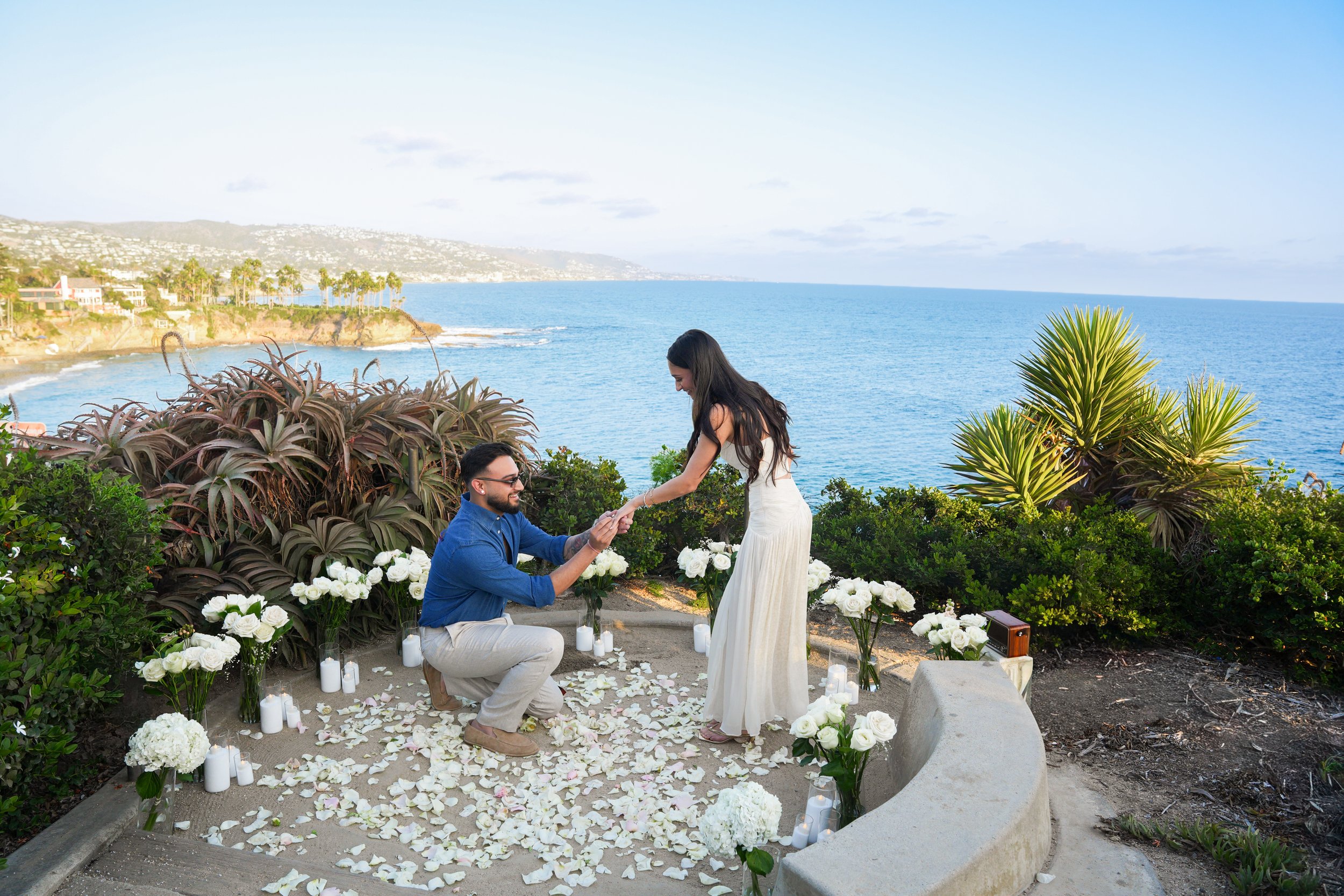 Laguna Beach surprise proposal with our Grand Floral setup featuring long-stem white roses and flameless candles.