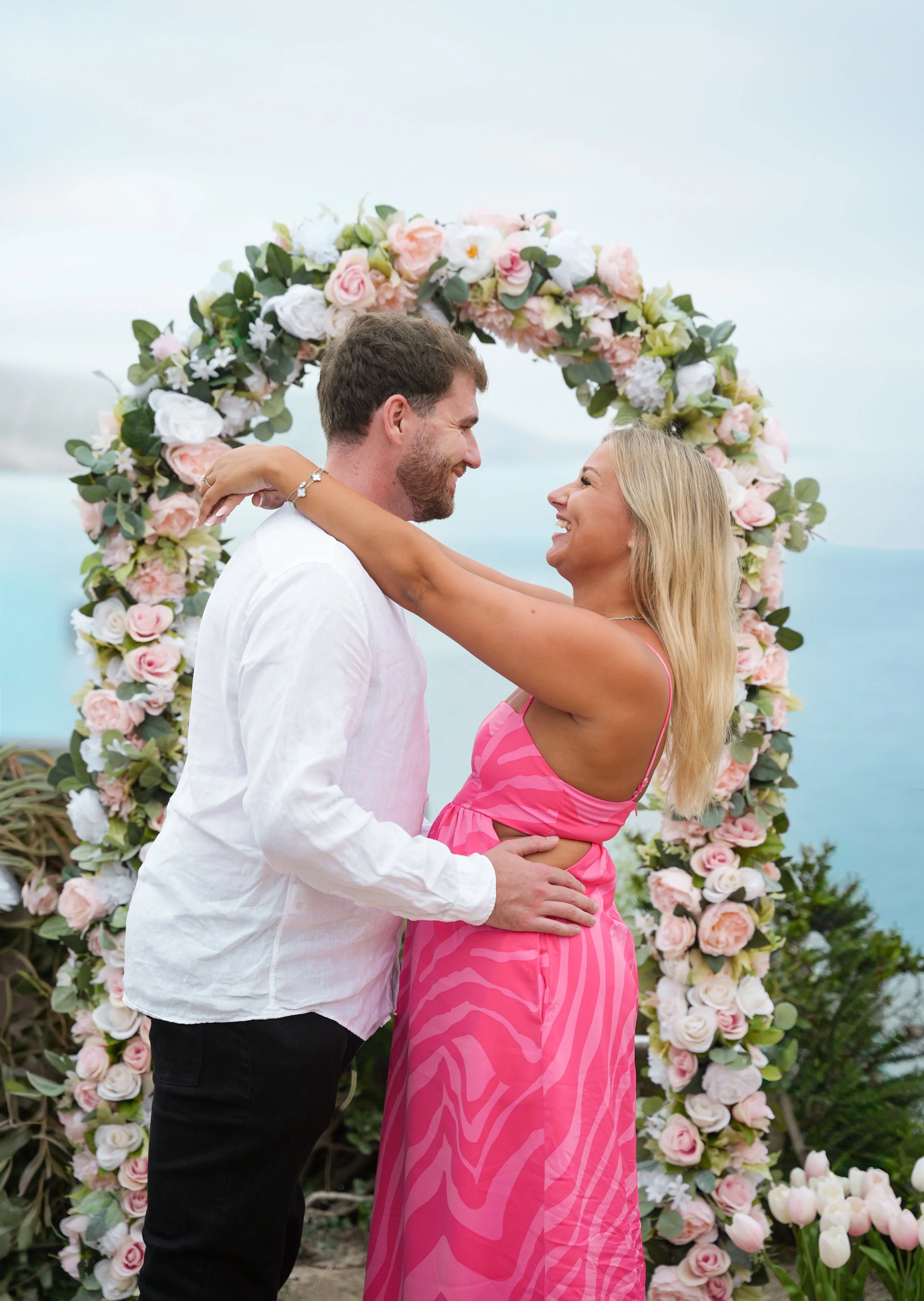 Laguna Beach surprise proposal with our Signature Yes full floral arch overlooking the ocean.