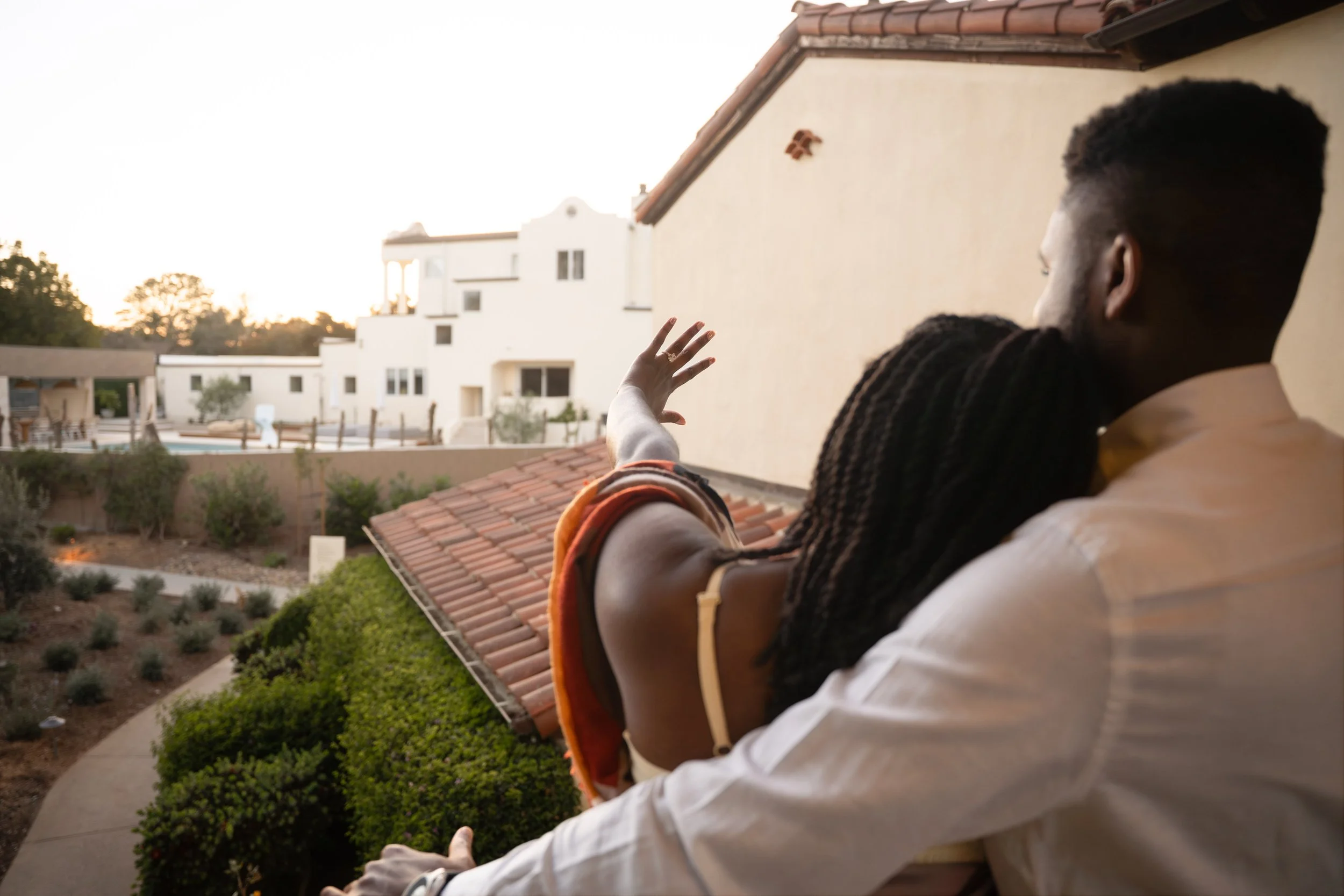 Couple admiring engagement ring on balcony at Estancia La Jolla Hotel & Spa after surprise proposal, La Jolla surprise proposal photographer capturing post-proposal moment in San Diego