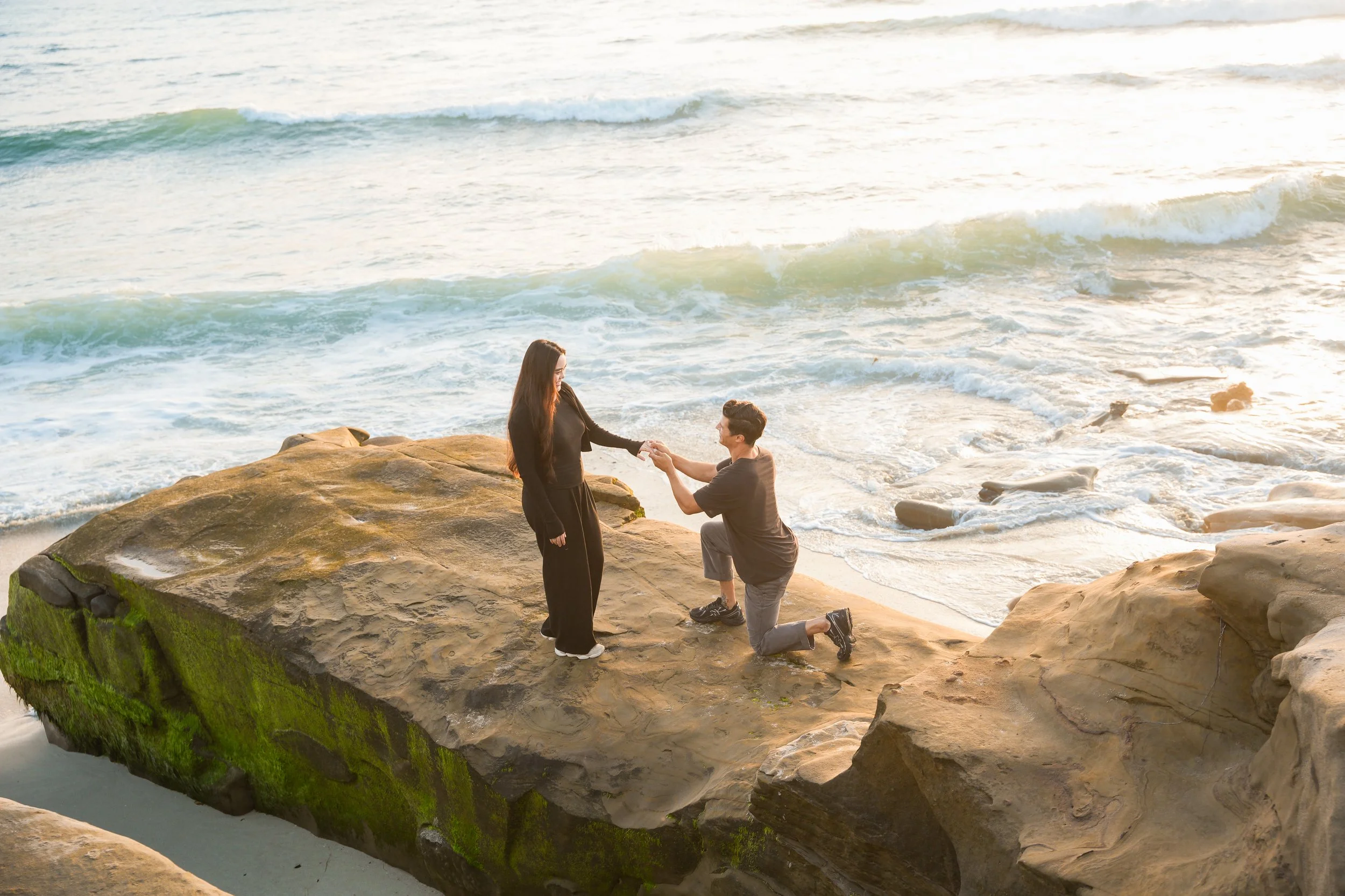 Windansea Beach sunset proposal on a moss-covered rock during low tide in La Jolla, San Diego.