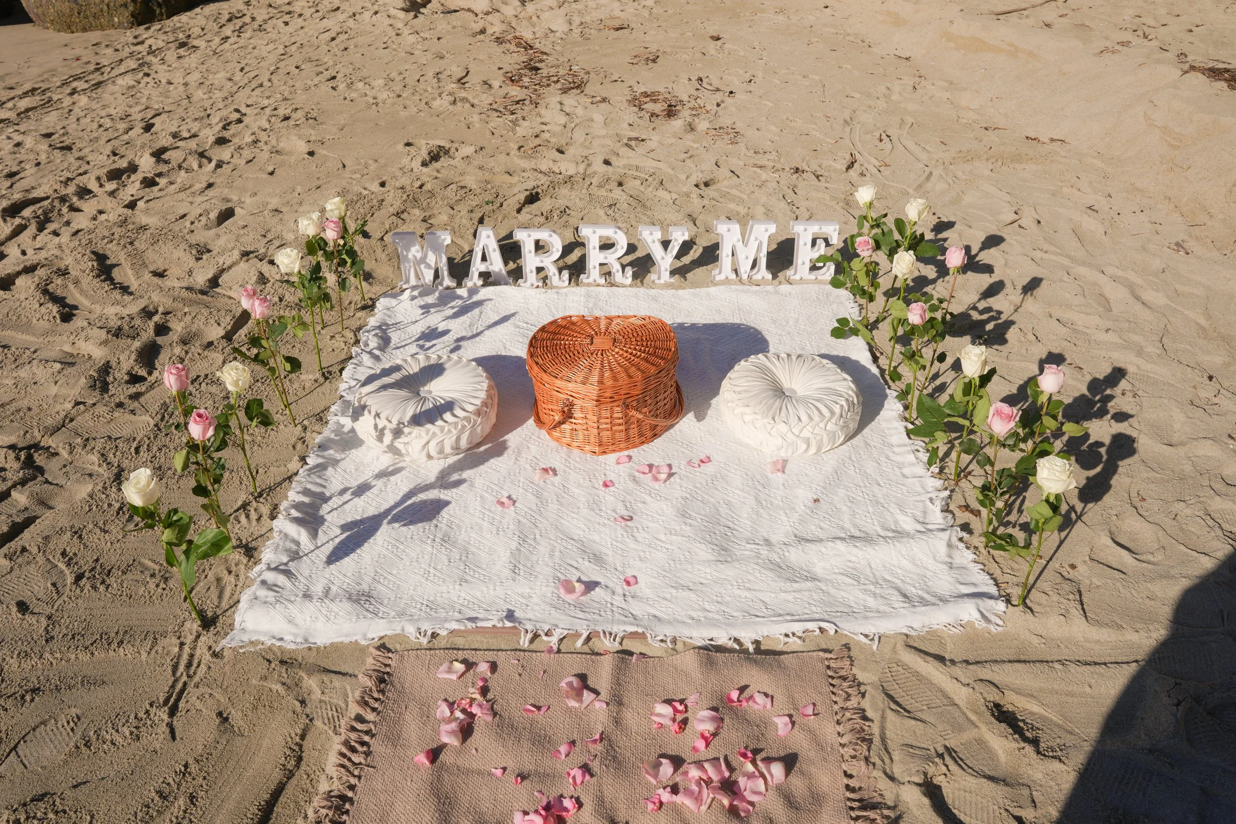 A styled Marry Me decor beach proposal setup transforming the shoreline into a romantic, photo-ready space for an unforgettable surprise proposal.