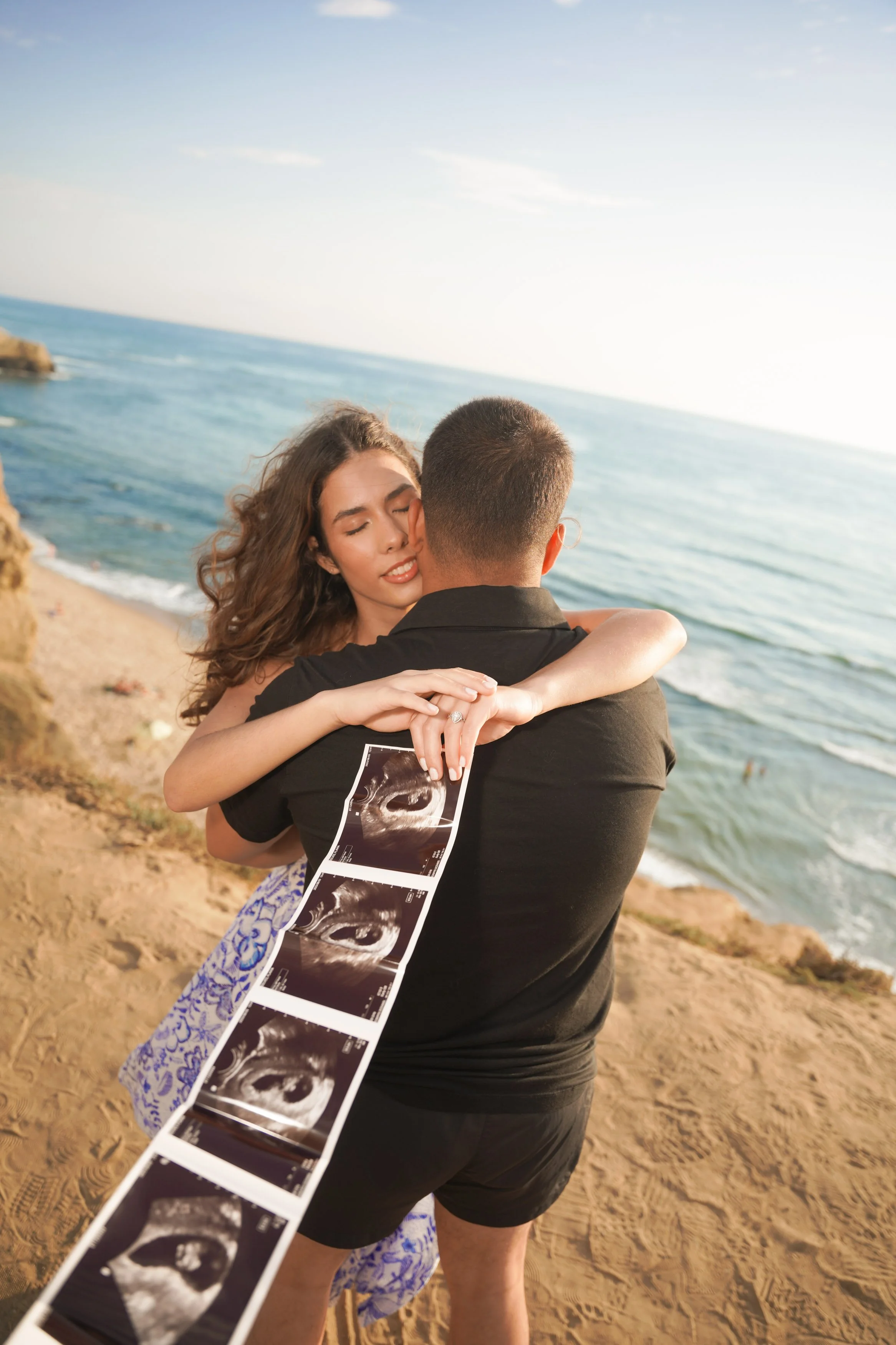 Golden hour baby announcement portraits at Sunset Cliffs San Diego with glowing natural light, sweeping ocean views, and timeless scenery, inquire today to capture your reveal session with us.