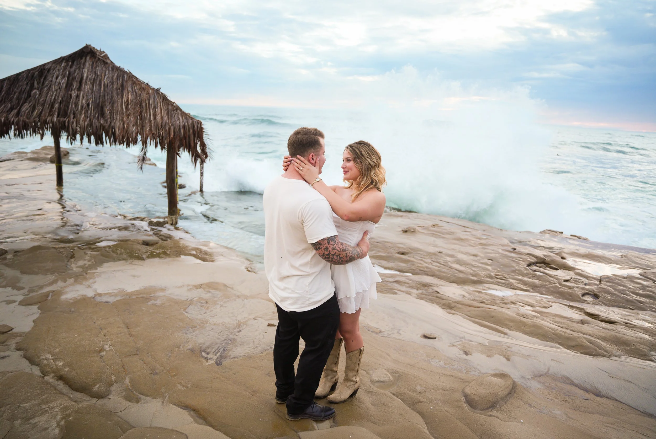 Newly engaged couple photographed in front of the iconic Windansea Surf Shack in La Jolla after booking our Last Minute Yes proposal package.