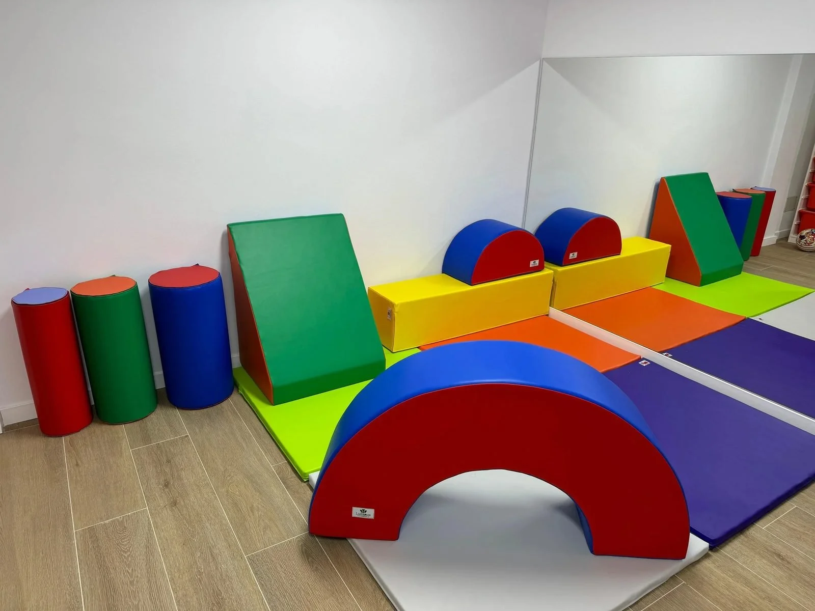 Juegos de espuma para niños en colores rojo, azul, verde y amarillo, en una sala de juegos infantil.