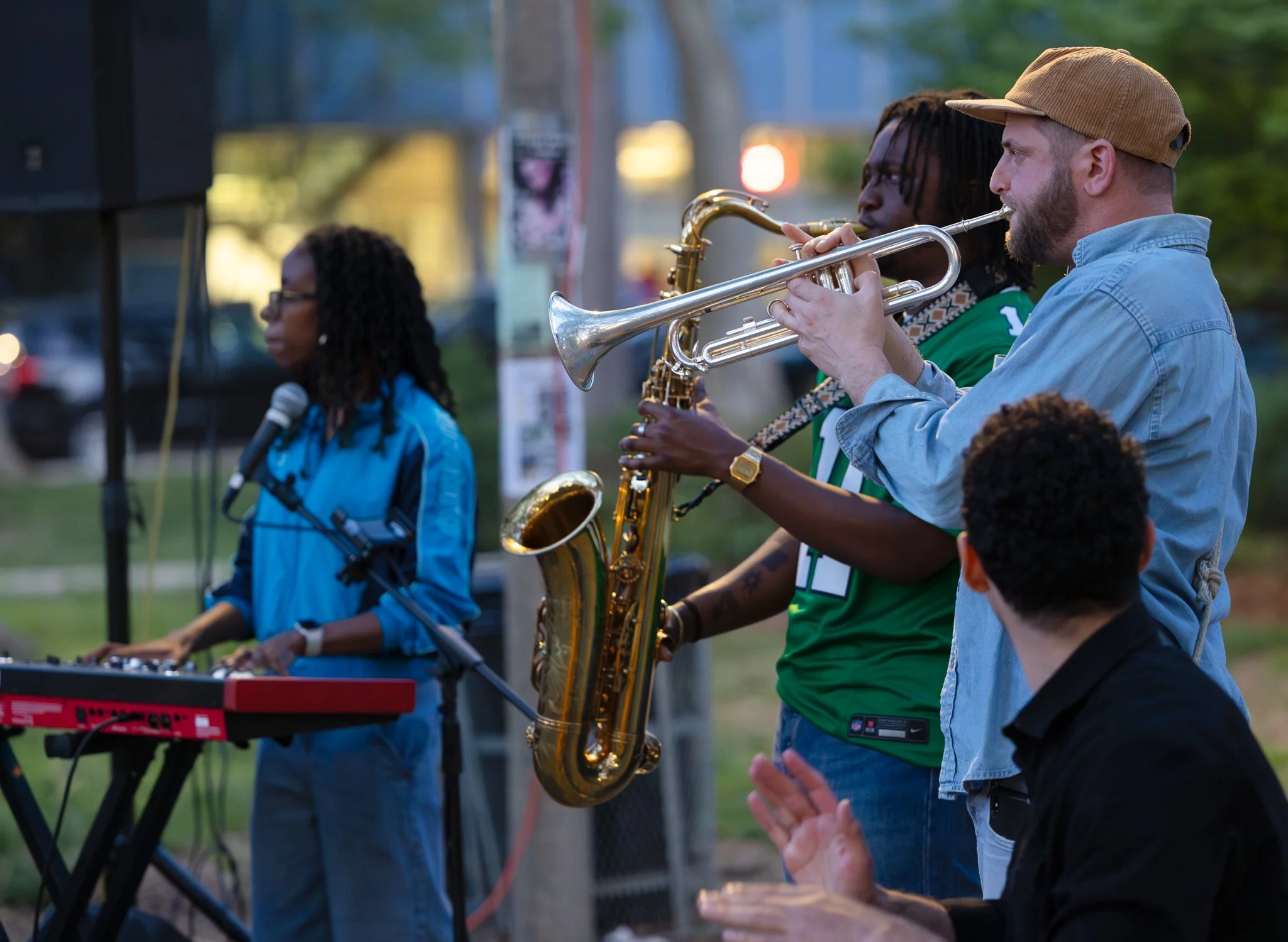 Local musicians playing jazz music outside a building in a parking lot.