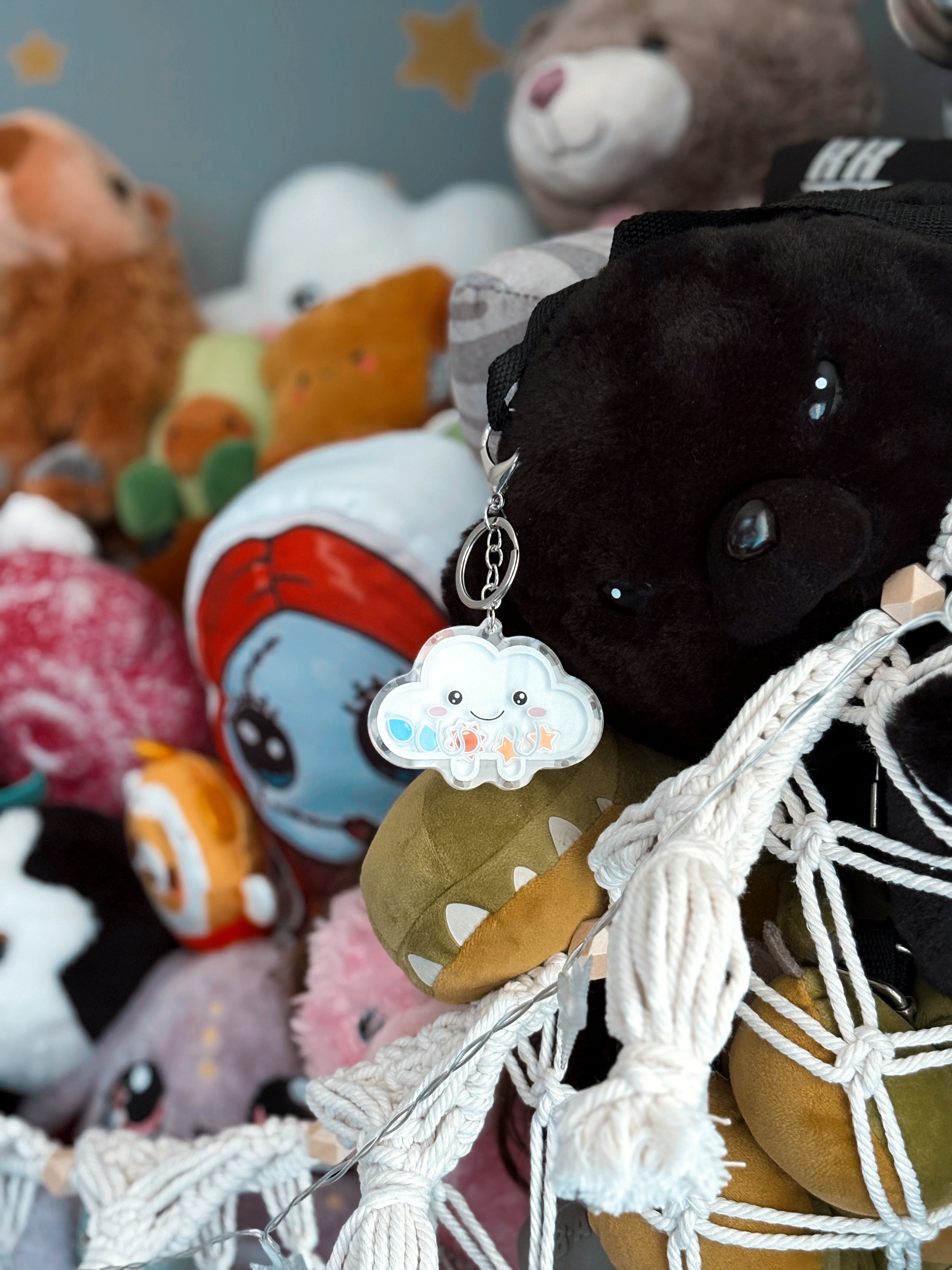 Cloud shaker keychain featuring small plush cloud characters resting on a soft plushie hammock, attached to a silver keyring, showcasing a cute and comforting accessory from The Cloud Project.