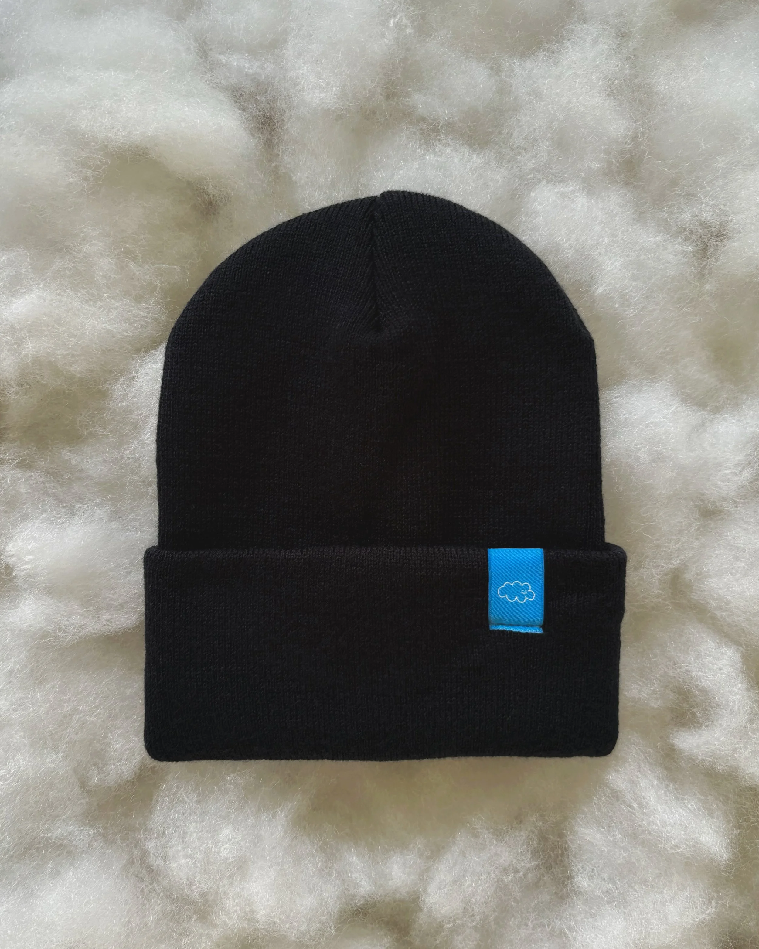 Head in the Clouds Beanie resting on a soft cloud background