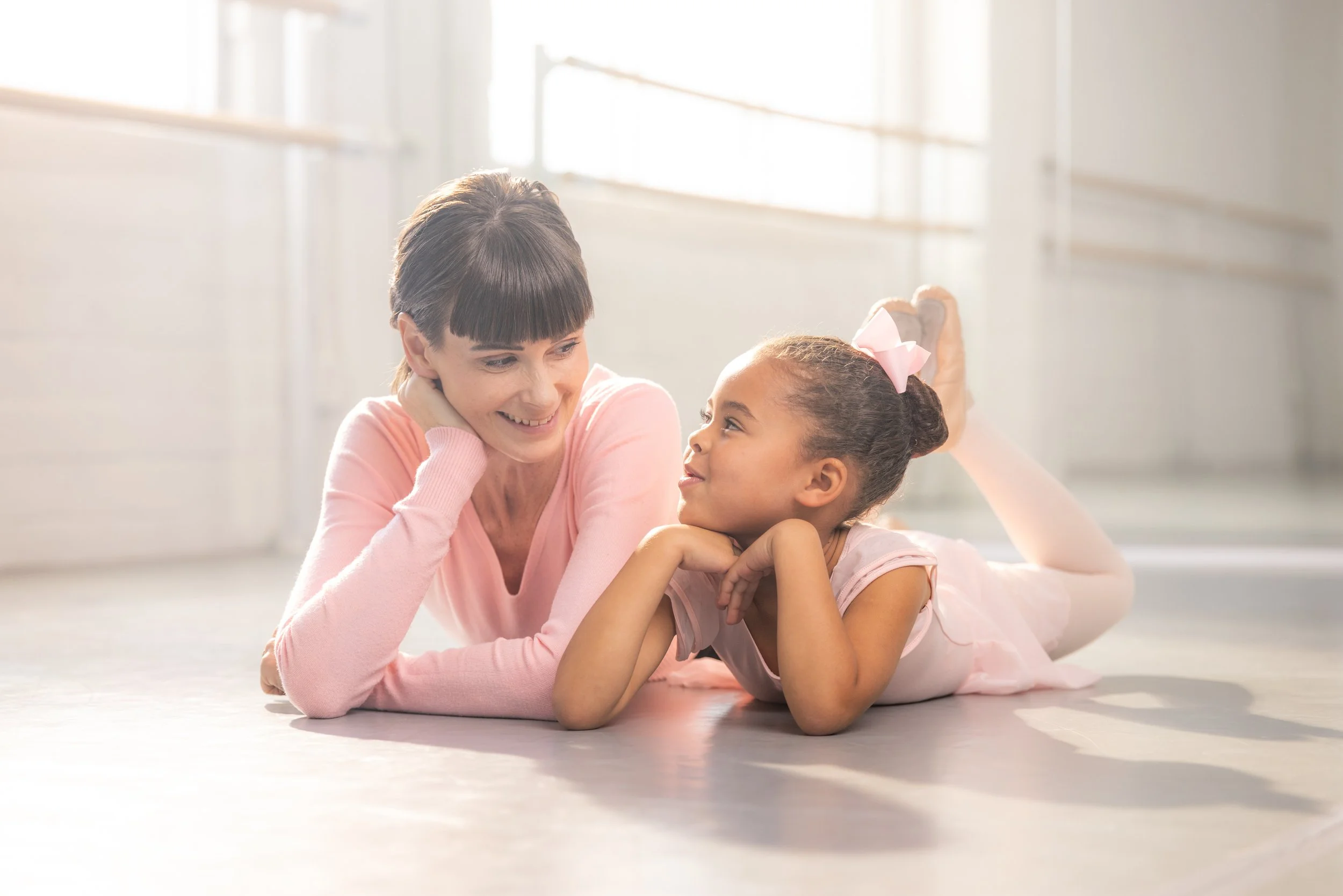 Miss Geraldine and young ballet student together in class smiling at each other