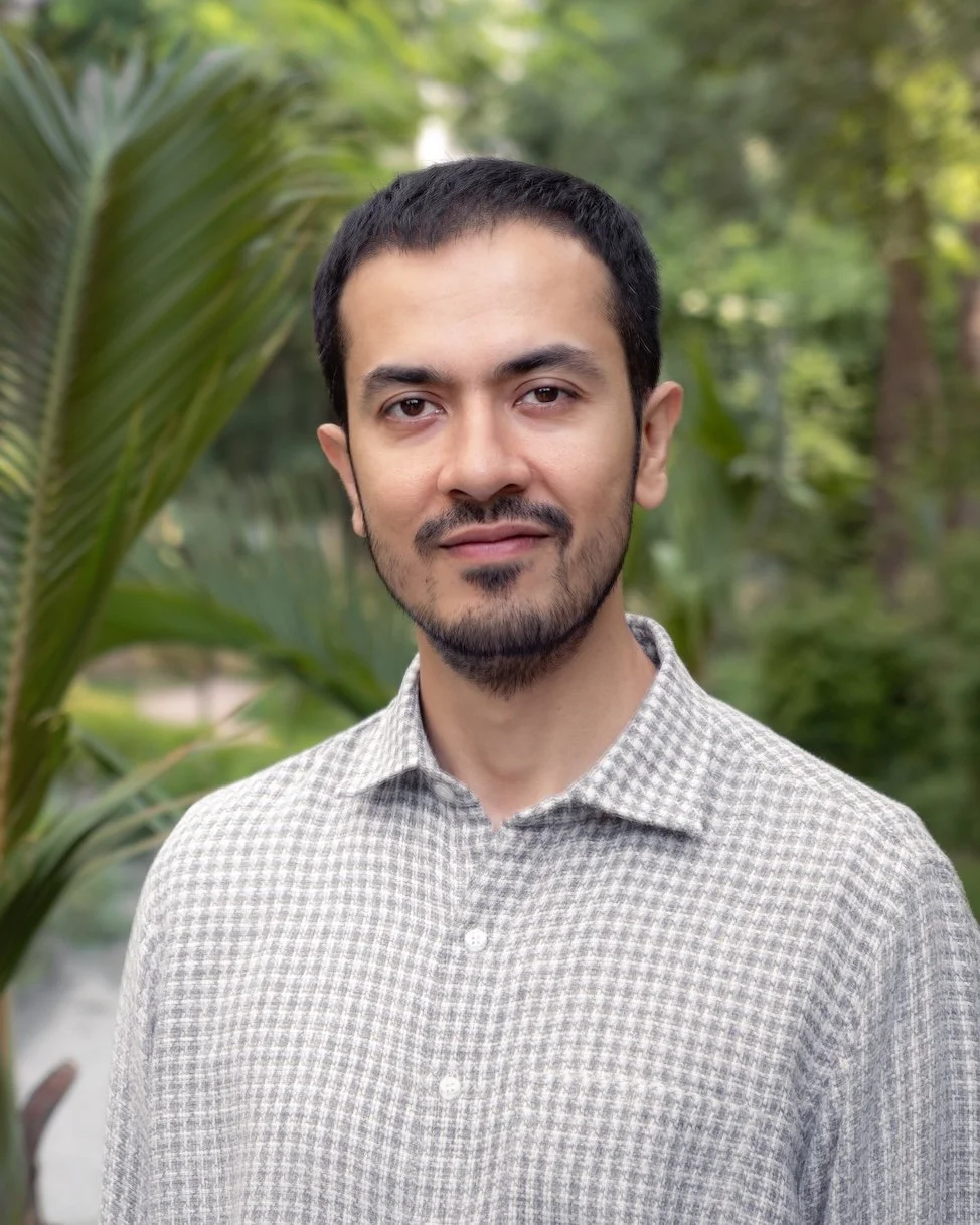 A man in a collared shirt smiling