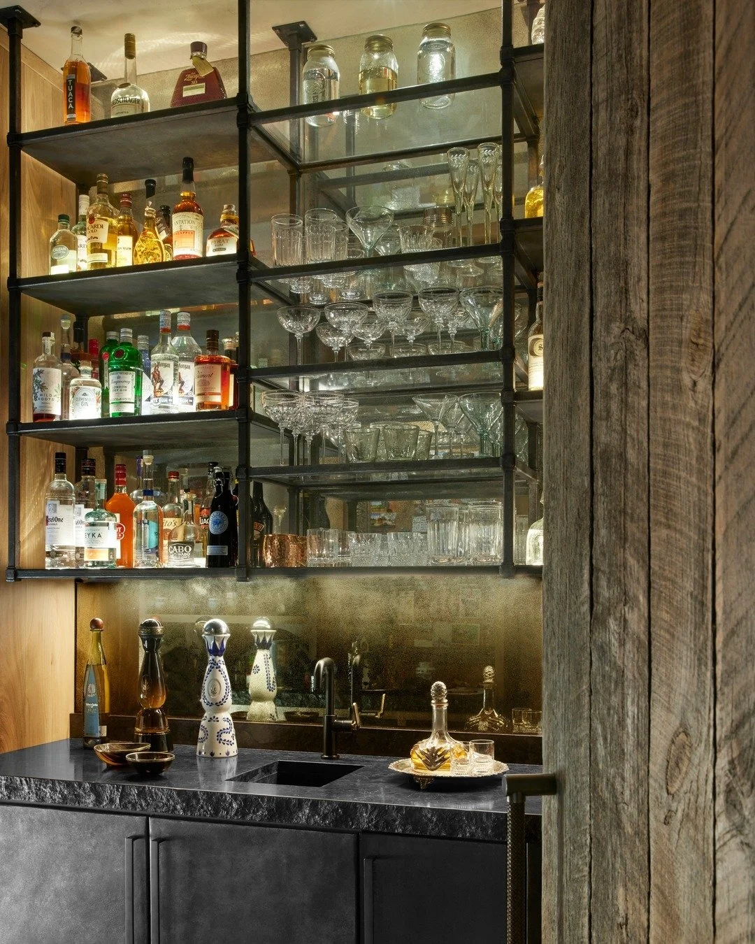 A bar designed for Fridays… and every night you decide deserves a little celebration. 🍸 Blackened steel meets an antique mirror glow, warm chiseled-edge quartzite grounds it, and woven leather pulls add the perfect touch. This isn’t jus