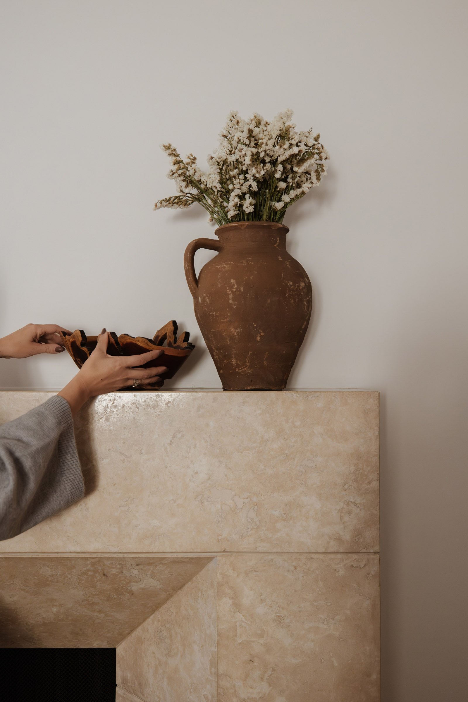 Stager placing bowl on a fireplace mantle