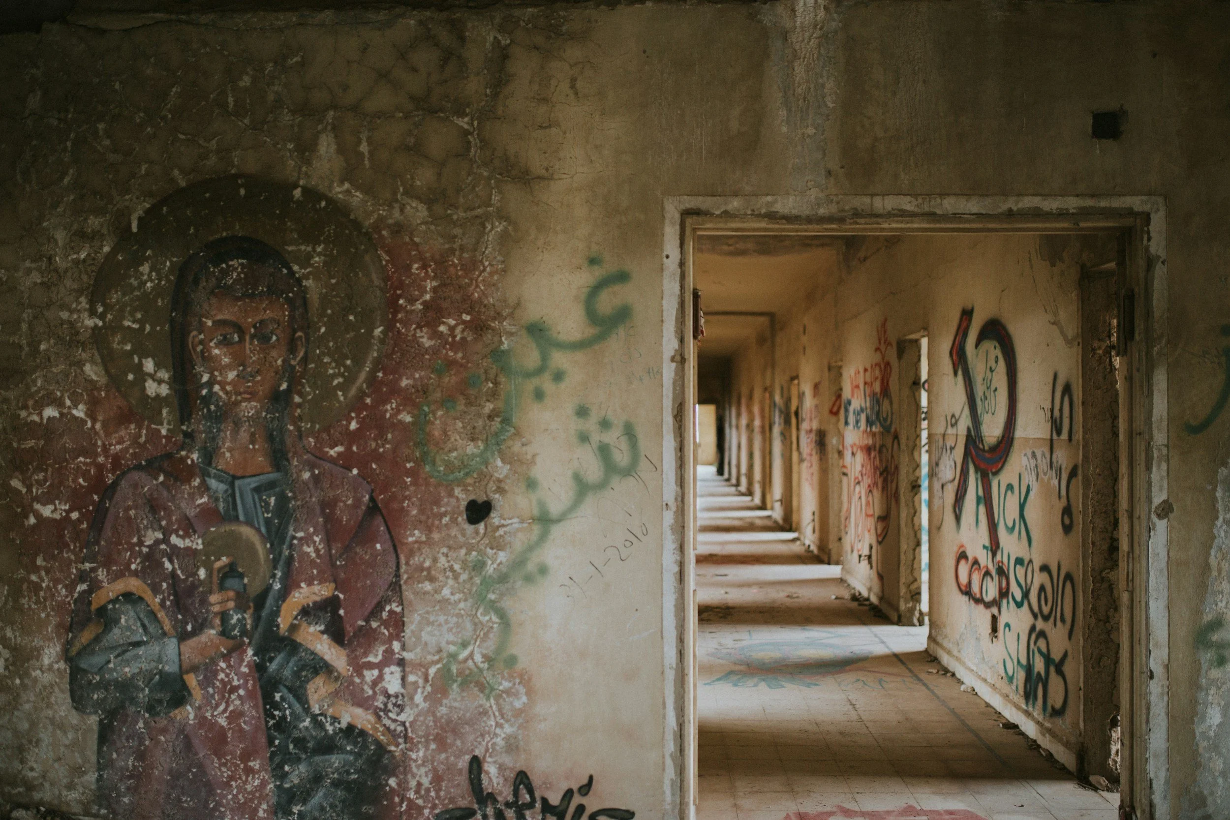 A long hallway of stone in Israel with street art showing.