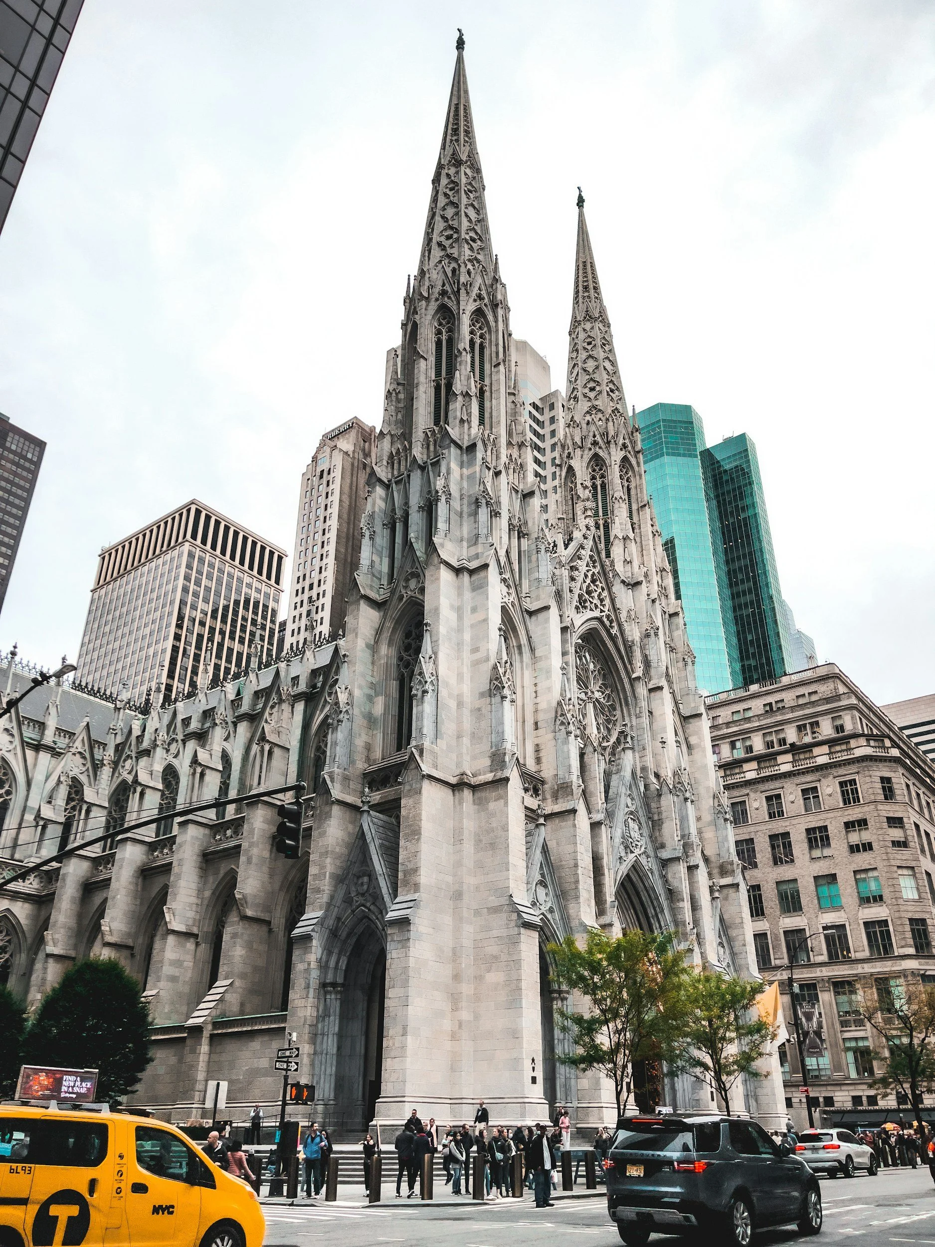A large white church in a metropolitan setting on the corner of a busy city street