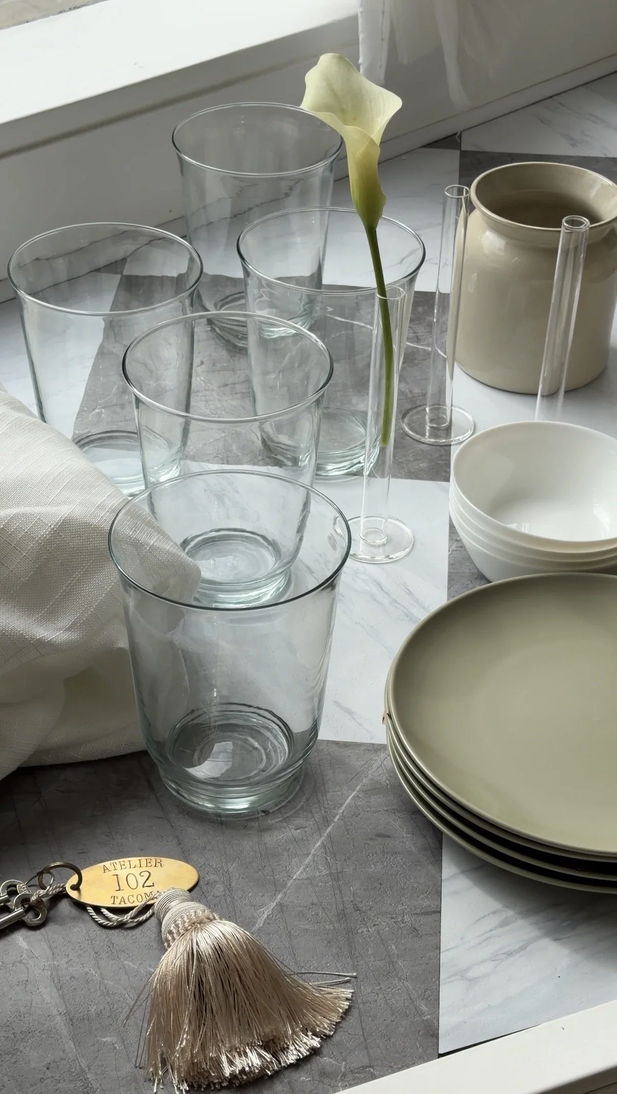 30 sage green plates, 30 white salad bowls, 5 clear vases, 5 ceramic vases, 16 clear single stem vases. 5 white linen tablecloths extra large