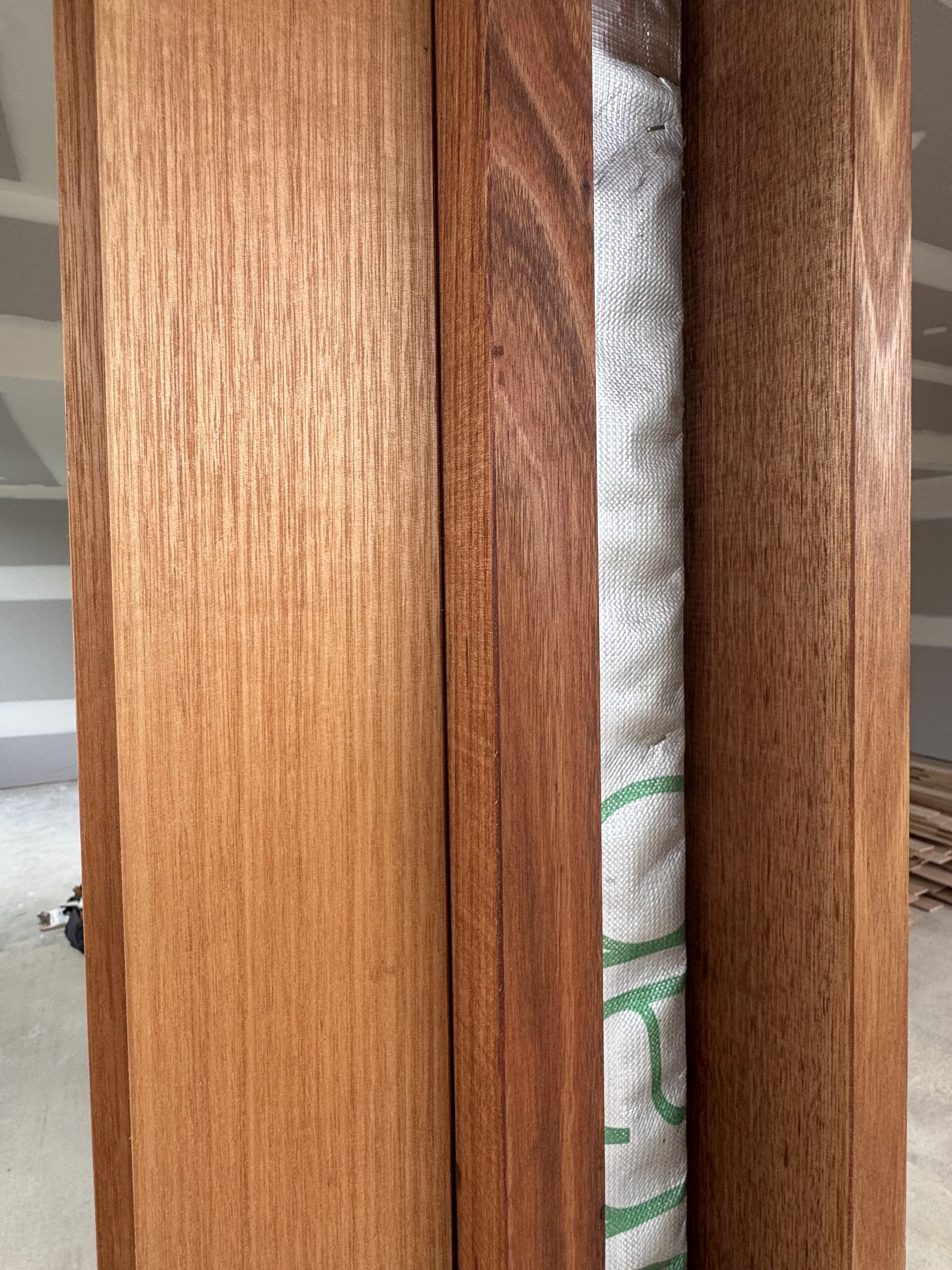 Close-up of wooden framing with insulation material visible between the wood studs.