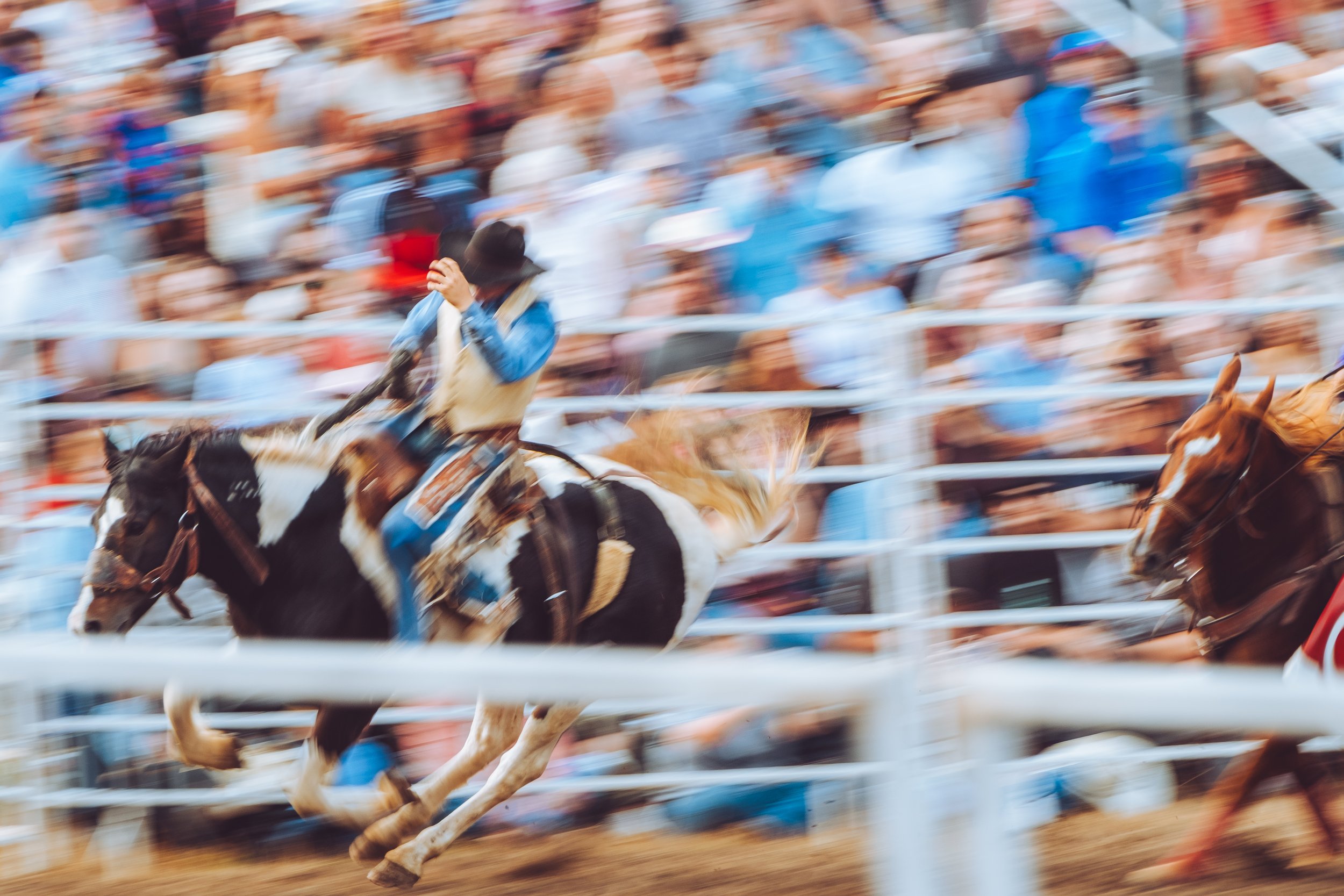 “Rodeo cowboy mid-ride under arena lights — Moncks Corner Pro Rodeo 2025”