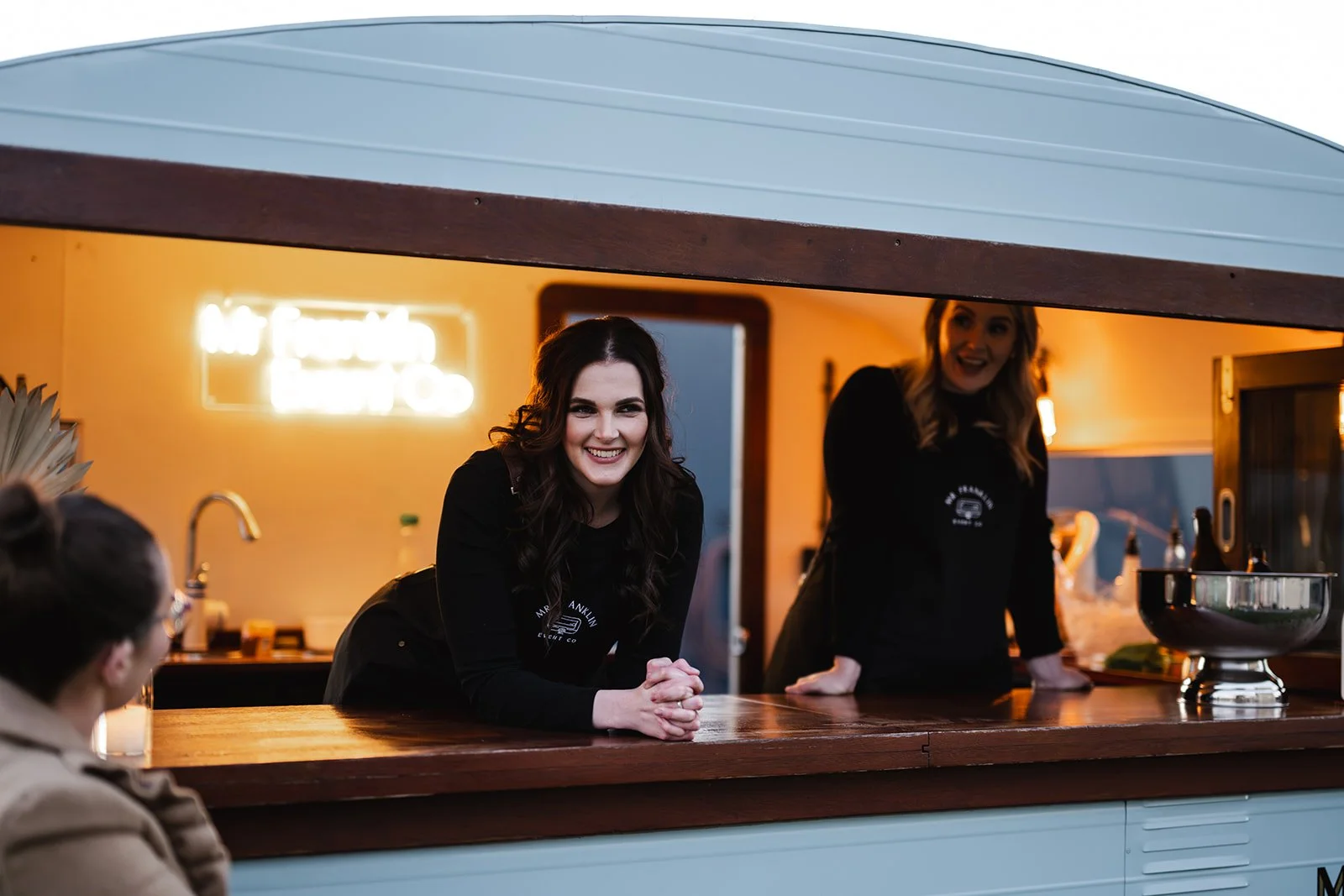 Maddy smiling looking out of  caravan