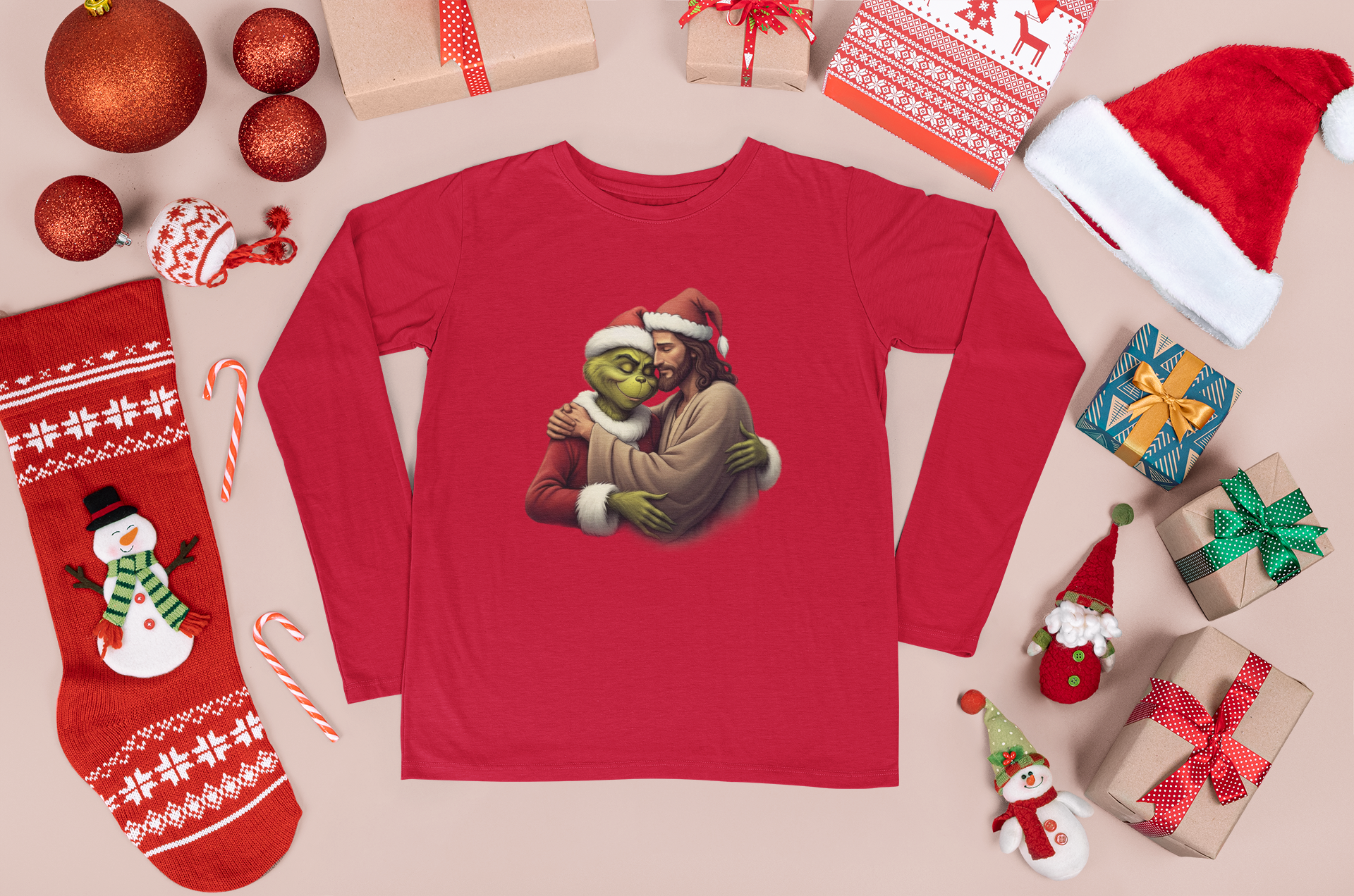 Tan background with various Christmas decor along bordering edges of image around red long sleeve tee shirt with image of Jesus hugging The Grinch on front