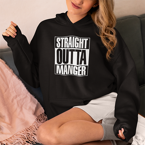 woman seated comfortably in shorts wearing black hoodie with logo reading STRAIGHT OUTTA MANGER