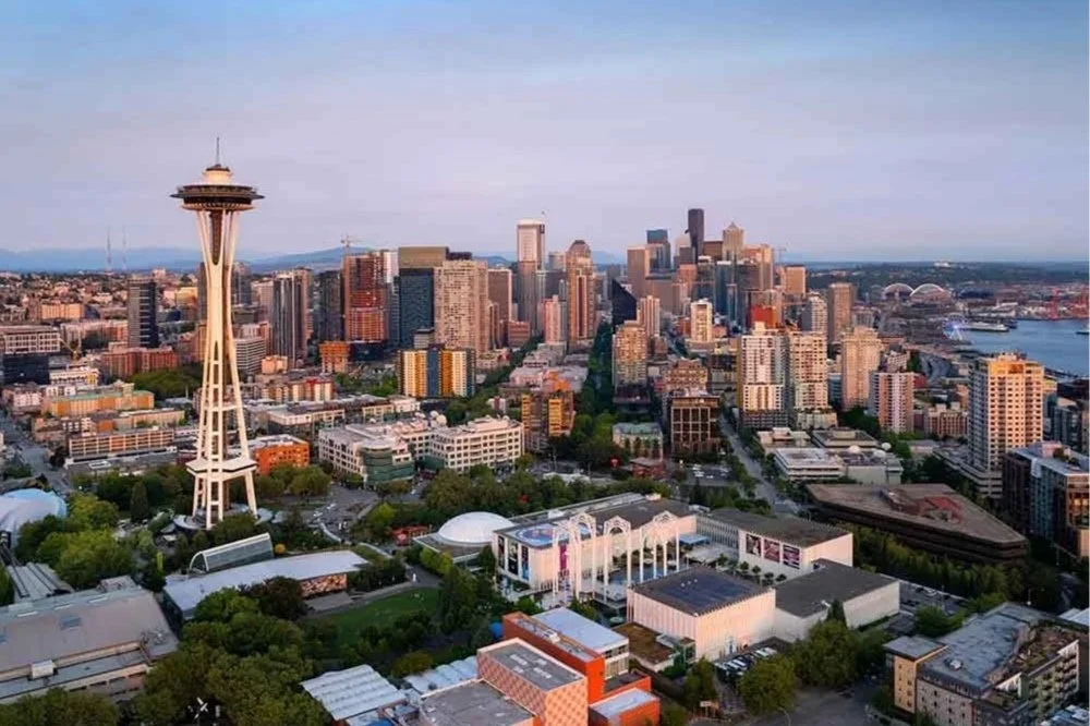 Aerial view of downtown Seattle, Washington, featuring the Space Needle, numerous skyscrapers, and the waterfront with boats and ships.