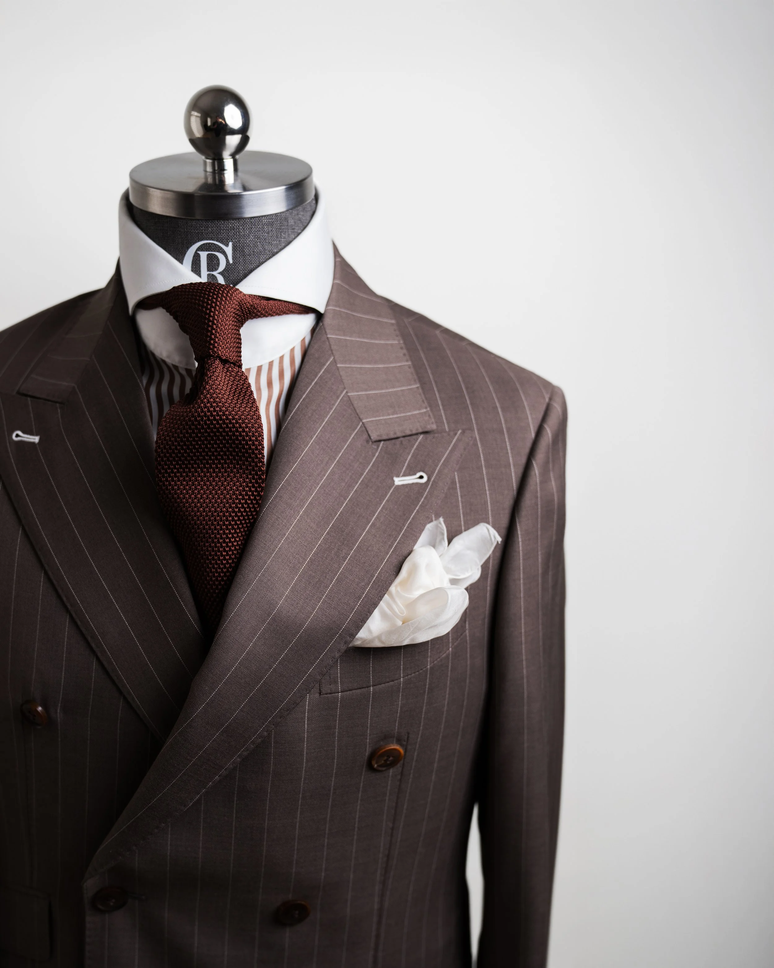 RC PINSTRIPE BROWN on a stand mannequin displaying the jacket paired with a pinstriped brown and white Raffiné Couture cutaway dress shirt