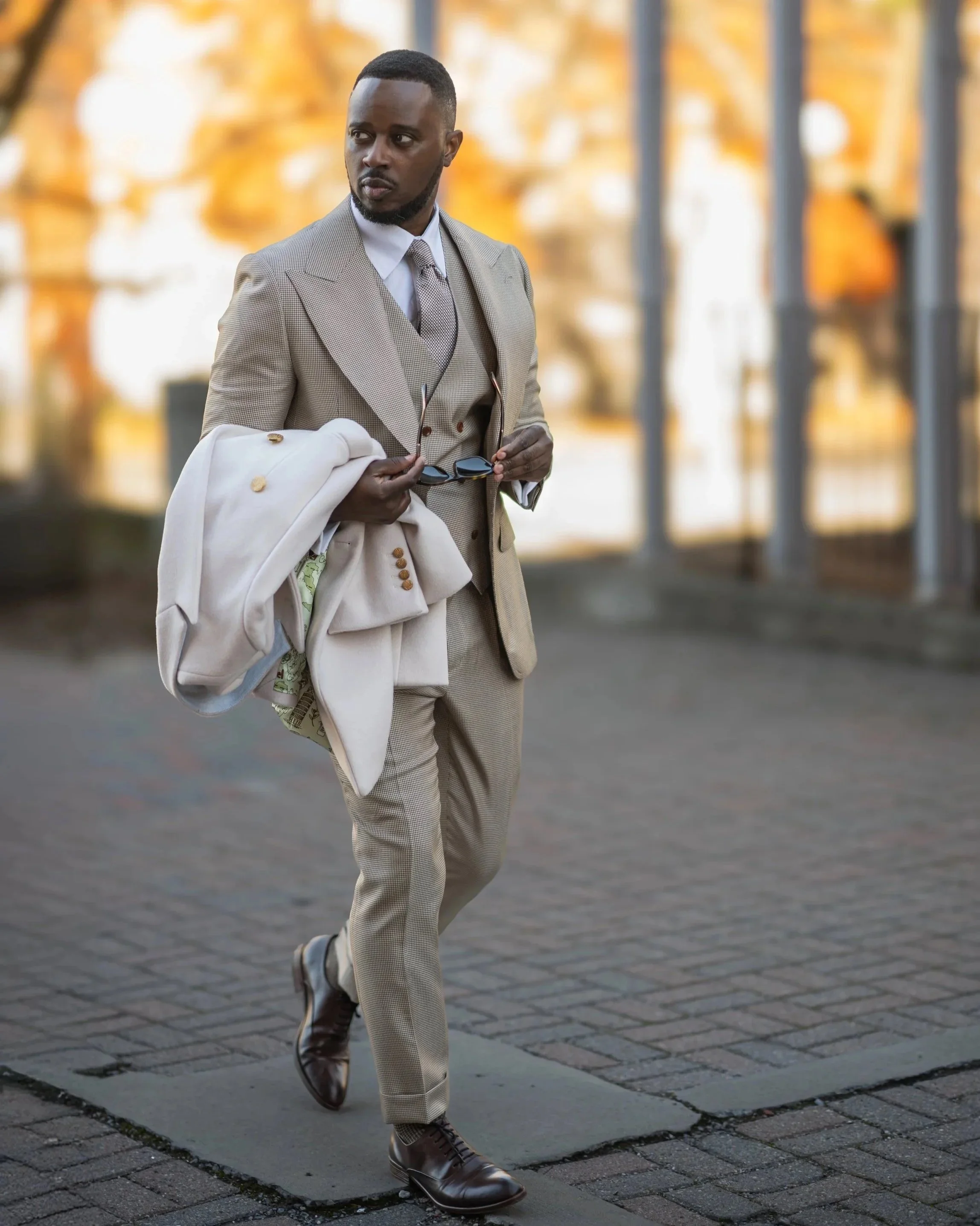 A man walking looking right wearing  RC Brown Houndstooth Three-Piece Suit