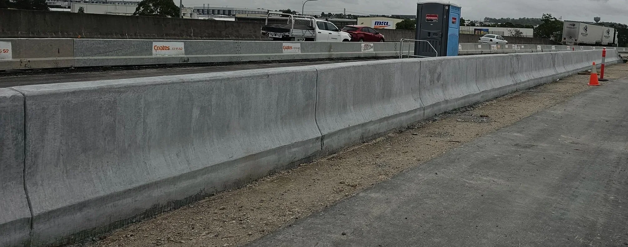 slipform barrier. TL3 TL4 TL5. slipform concrete barrier. safety barrier. Slipform contractor. slipform paving. concrete barrier installation.