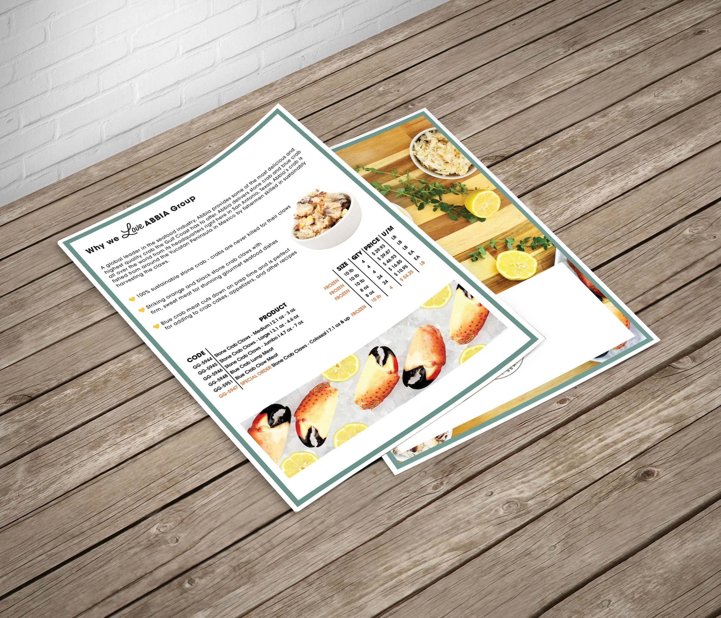 Printed restaurant menu on wooden floor showcasing seafood dishes and prices, including images of cooked crab claws and lemon wedges. Background features white brick wall.