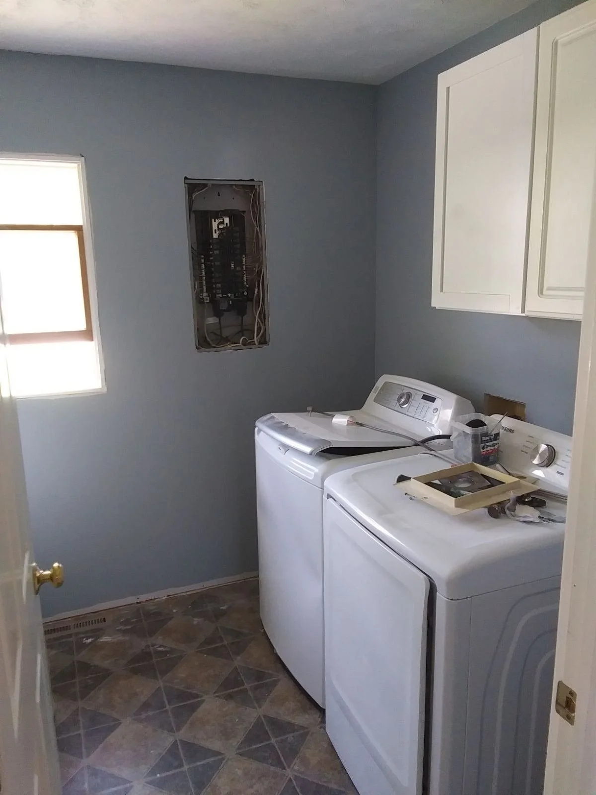 laundry room with washer, dryer, and open electrical panel