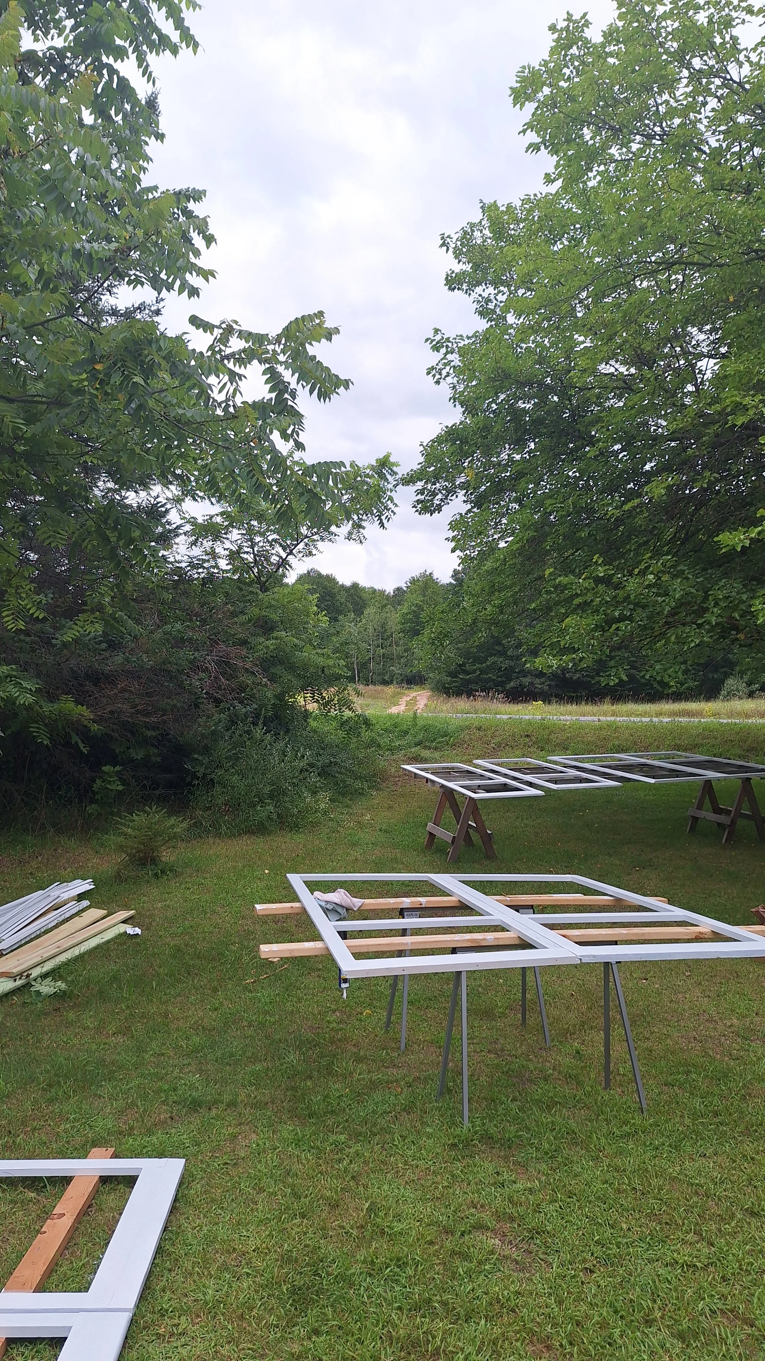 outdoor scene with wooden frames on sawhorses and trees