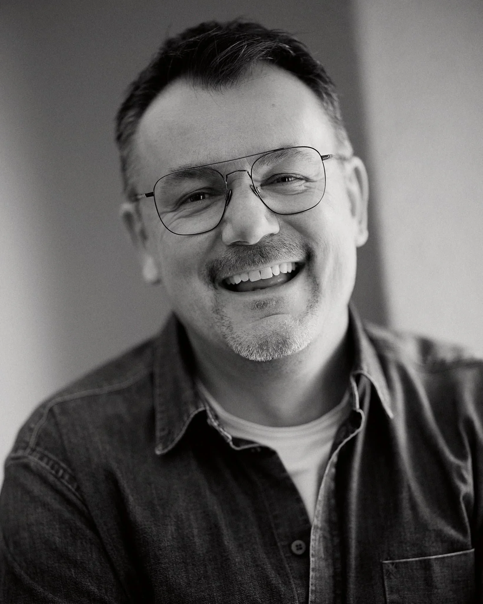 Freundlich lachender Mann mit Brille s/w