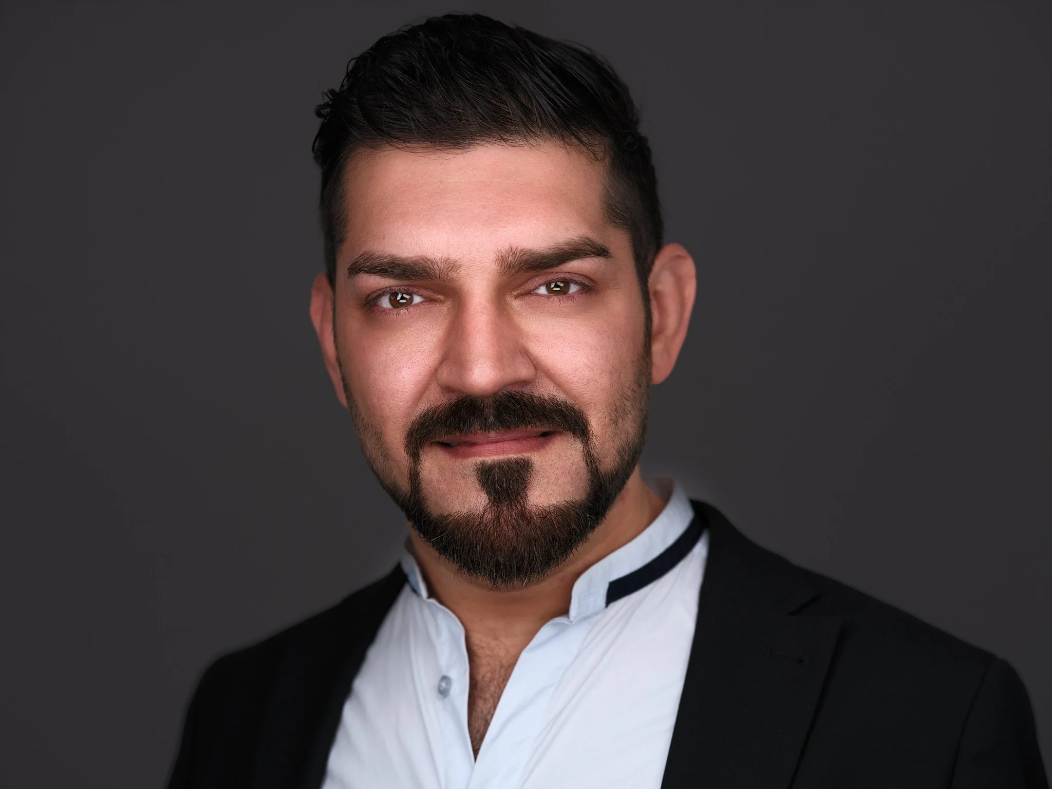 Freundlicher Mann mit Bart im schwarzen s/w Sakko