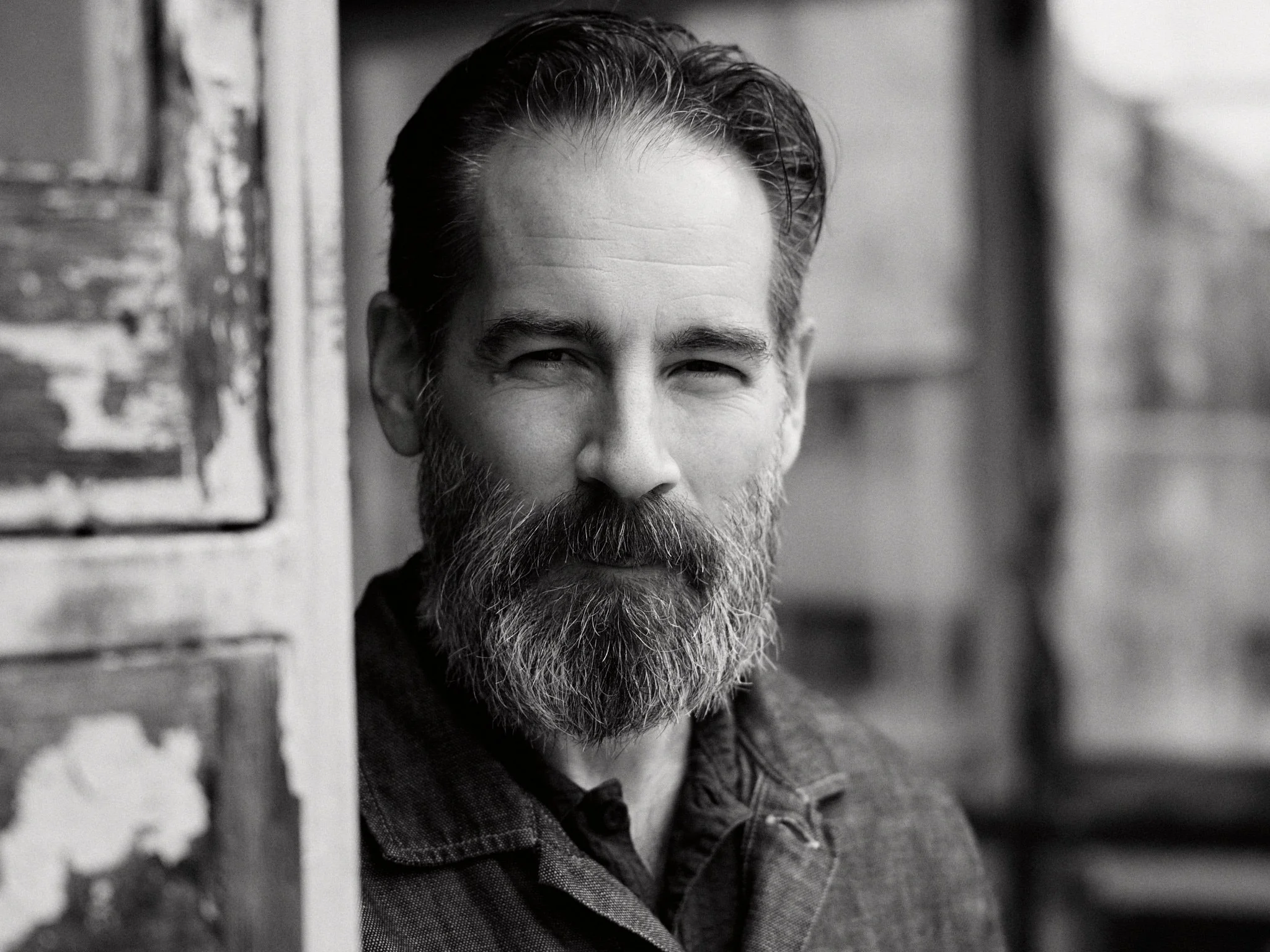 Mann mit Vollbart in alter Scheune s/w