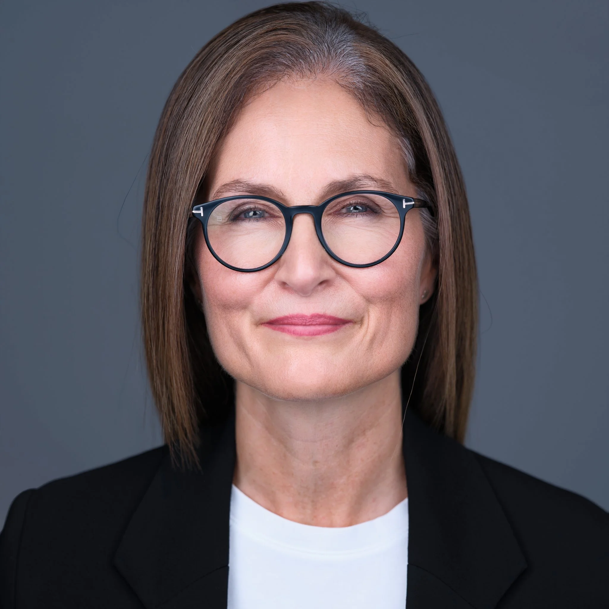 Elegante Frau mit Brille und glatten brünetten Haaren